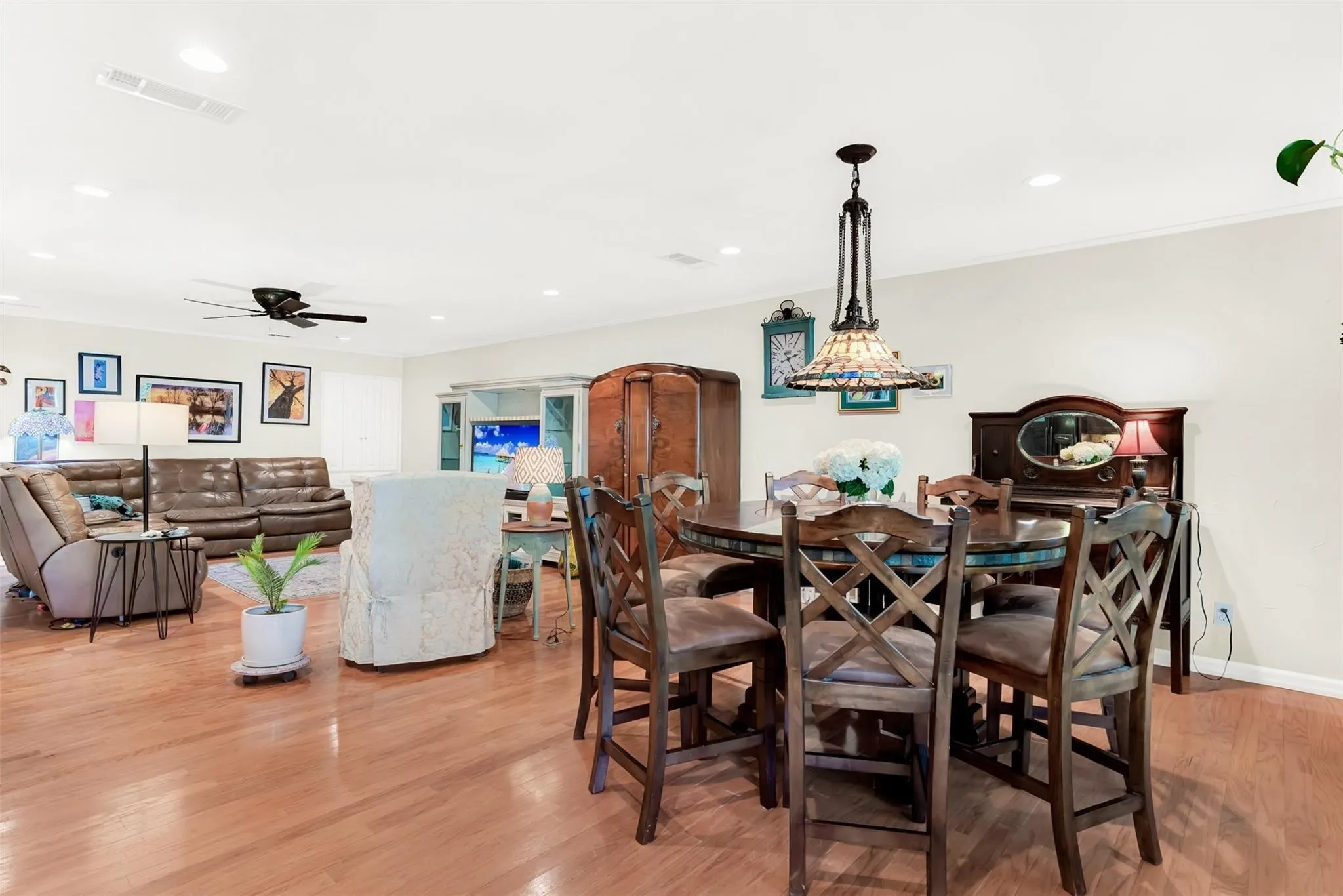 Wood-finish flooring throughout, recessed lighting, ceiling fan, and an ornate pendant light fixture