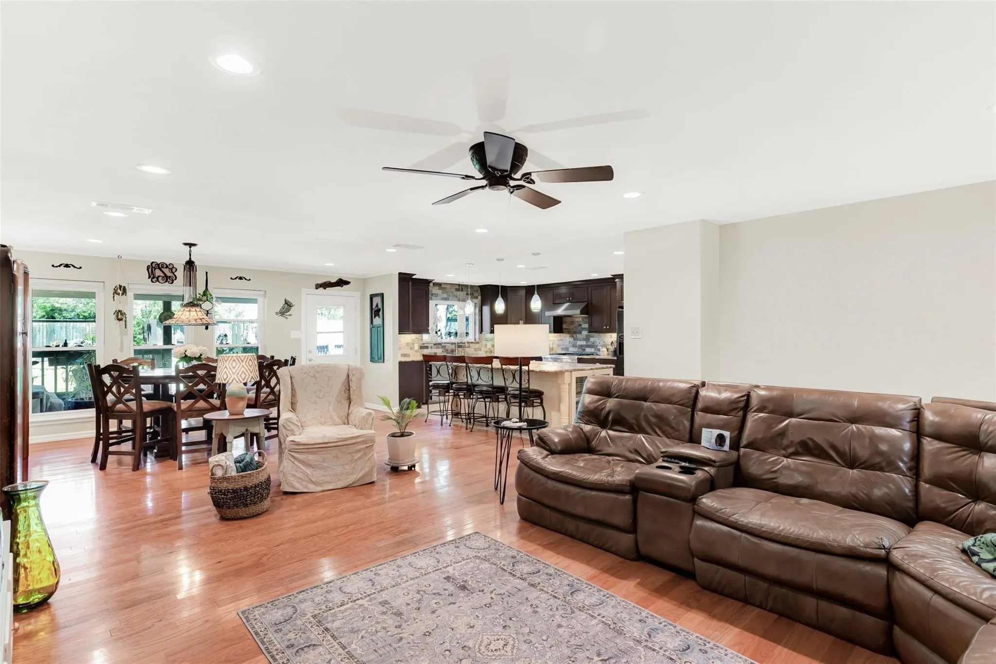 Open-concept living space featuring wood-finish flooring, recessed lighting, and a ceiling fan