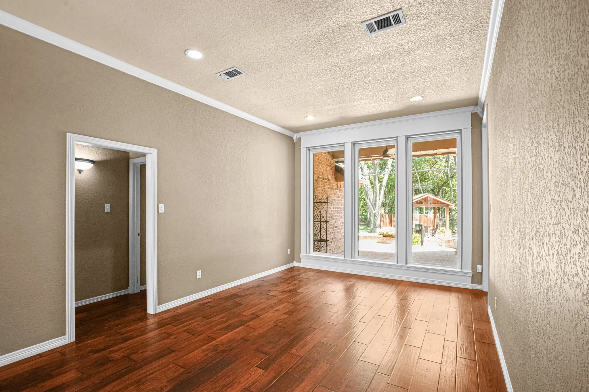 Wood-finish flooring, recessed lighting, and crown molding