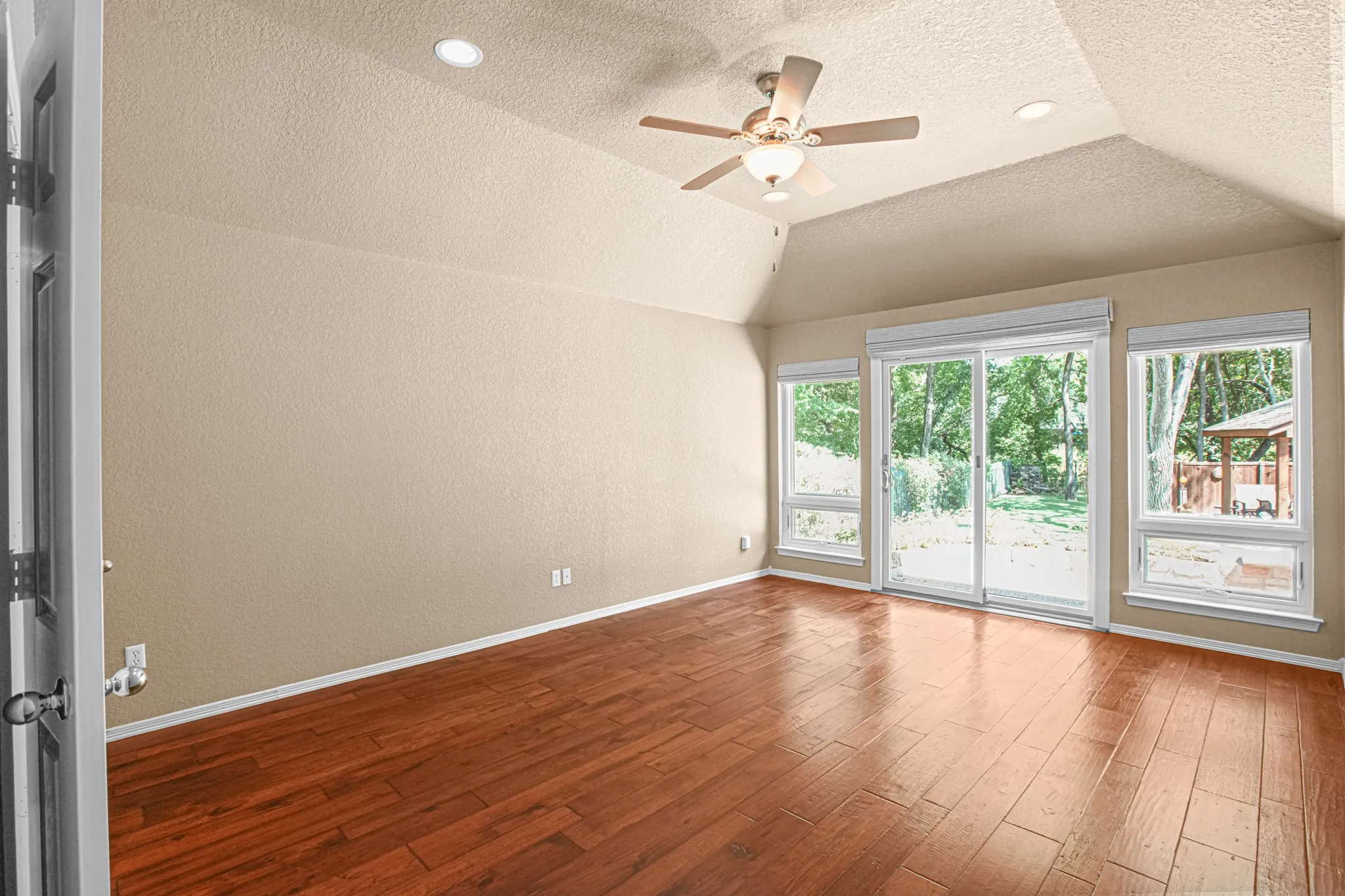 Vaulted ceilings with recessed lighting and a ceiling fan