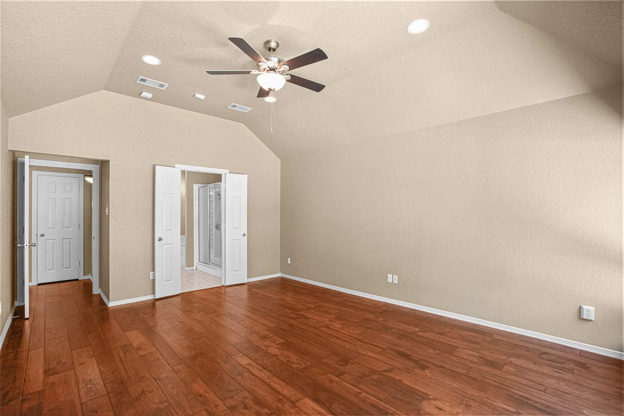 Vaulted ceiling with recessed lighting and a ceiling fan, wood-finish flooring, and white interior doors