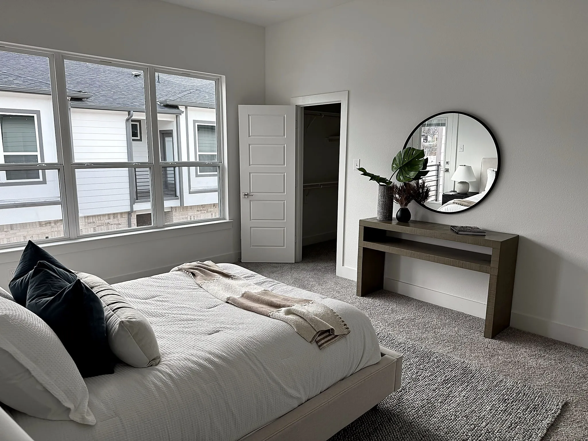 Room featuring neutral carpeting, a large multipane window, and a white paneled door