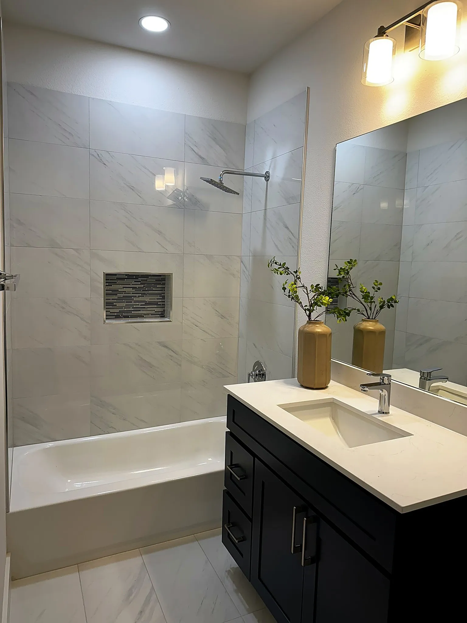 Bathroom featuring a single vanity with a white countertop, dark cabinetry, and a rectangular sink