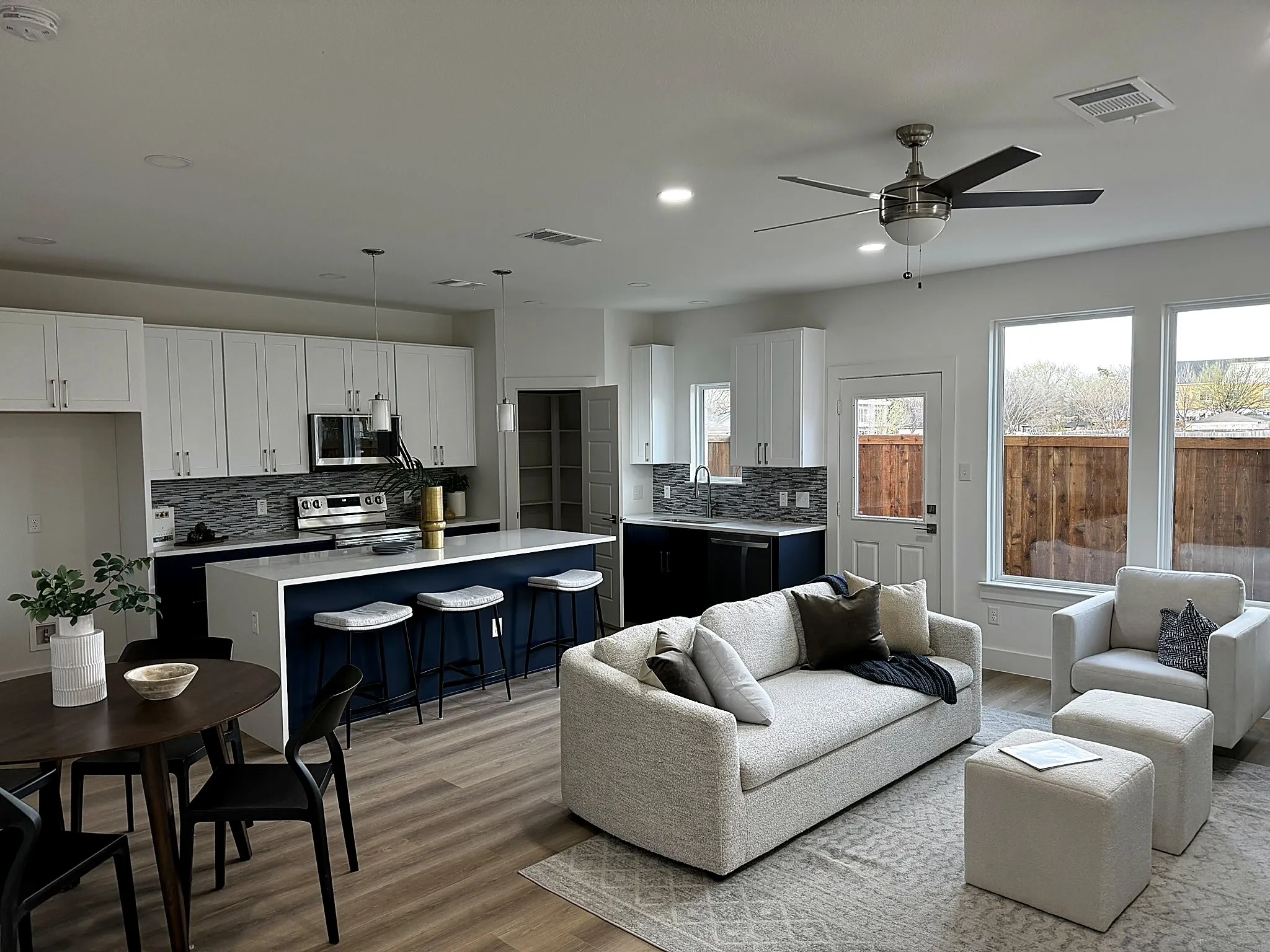 Open-concept living space with wood-finish flooring, a contemporary ceiling fan, and recessed lighting
