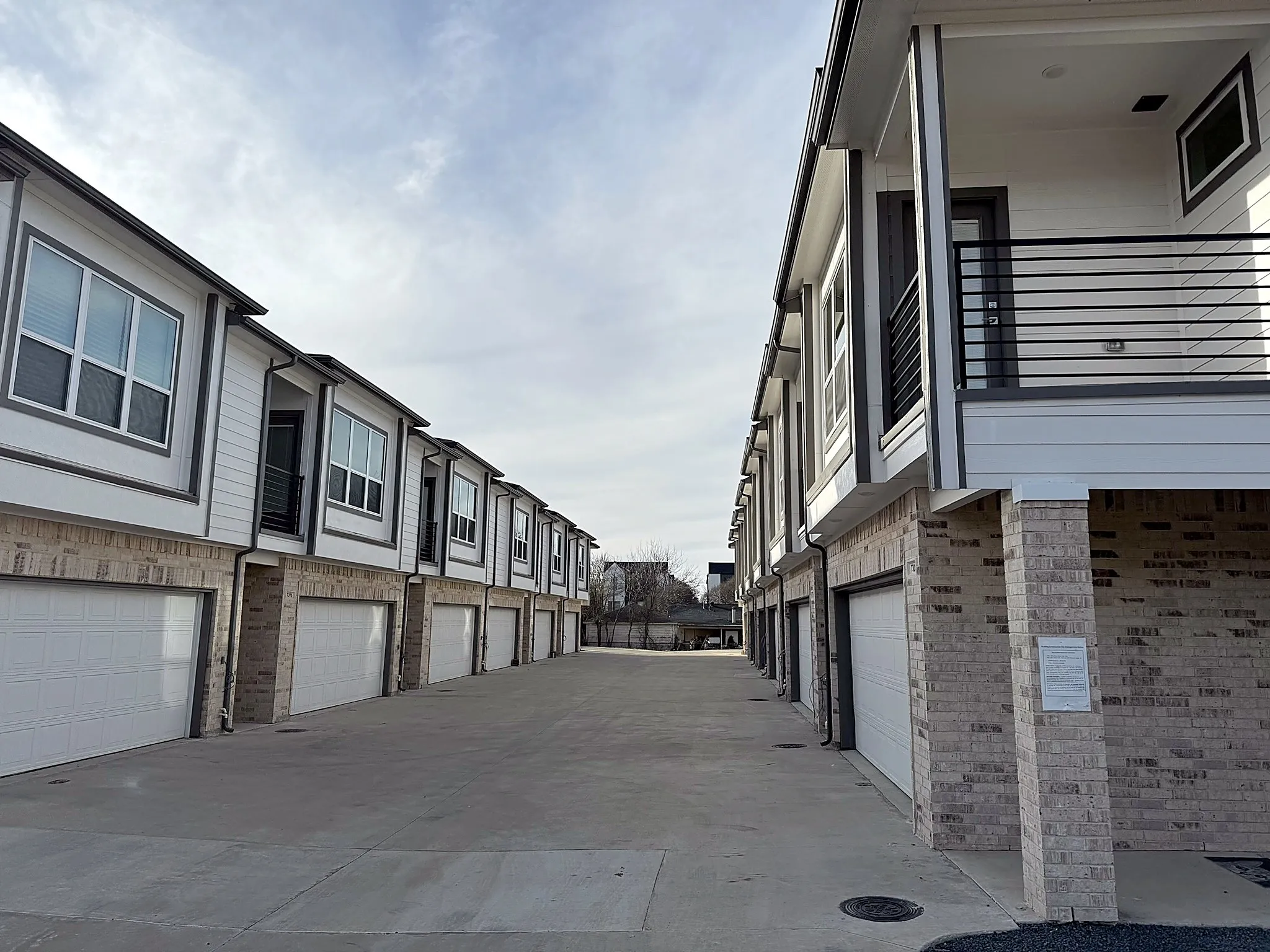 Contemporary townhome exteriors featuring white siding and light-toned brick accents