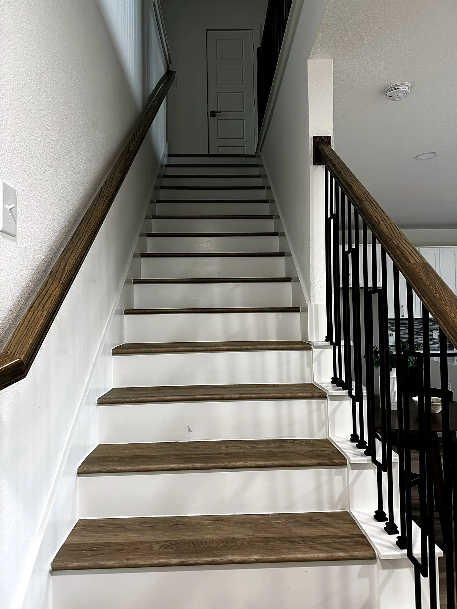 Staircase featuring wood-finish treads and white risers