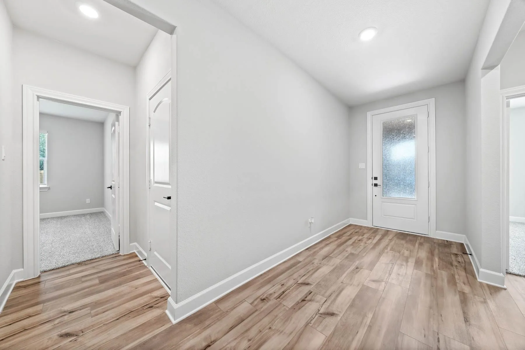 Entryway with light wood-type flooring and recessed lighting