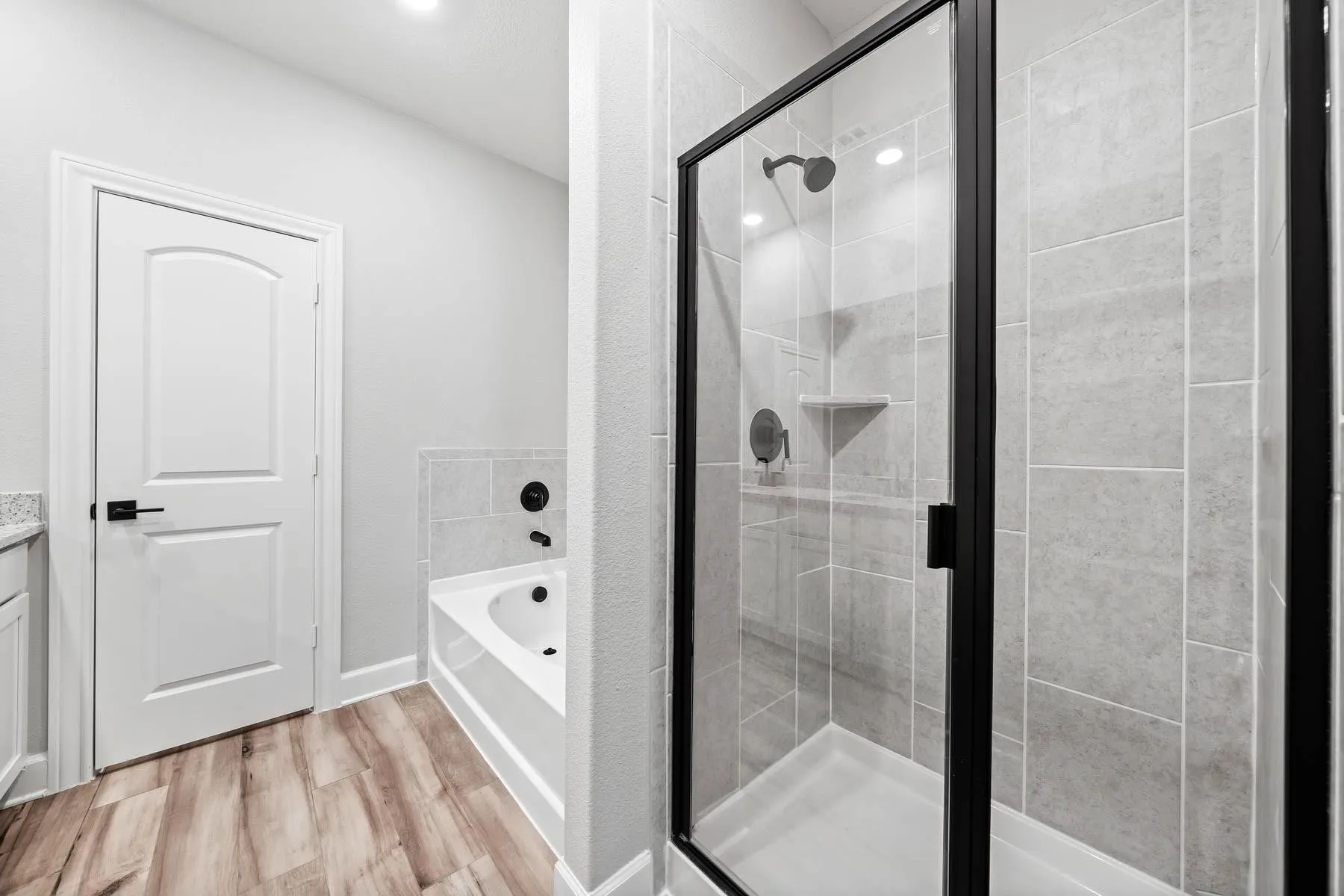 Full bathroom featuring a garden tub, a shower stall, light wood-style flooring, and vanity