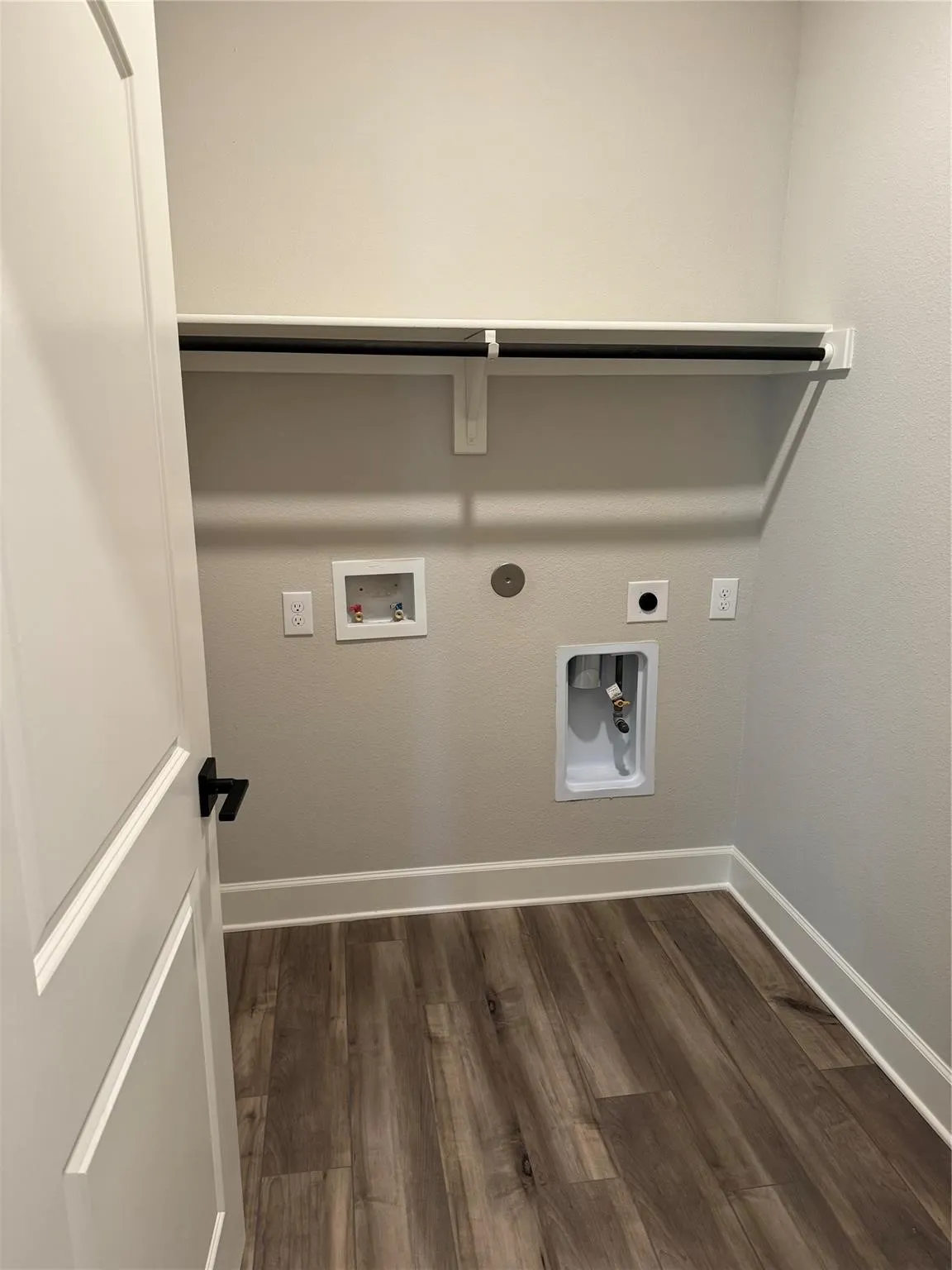 Washroom with dark wood-style flooring, washer hookup, hookup for an electric dryer, and gas dryer hookup