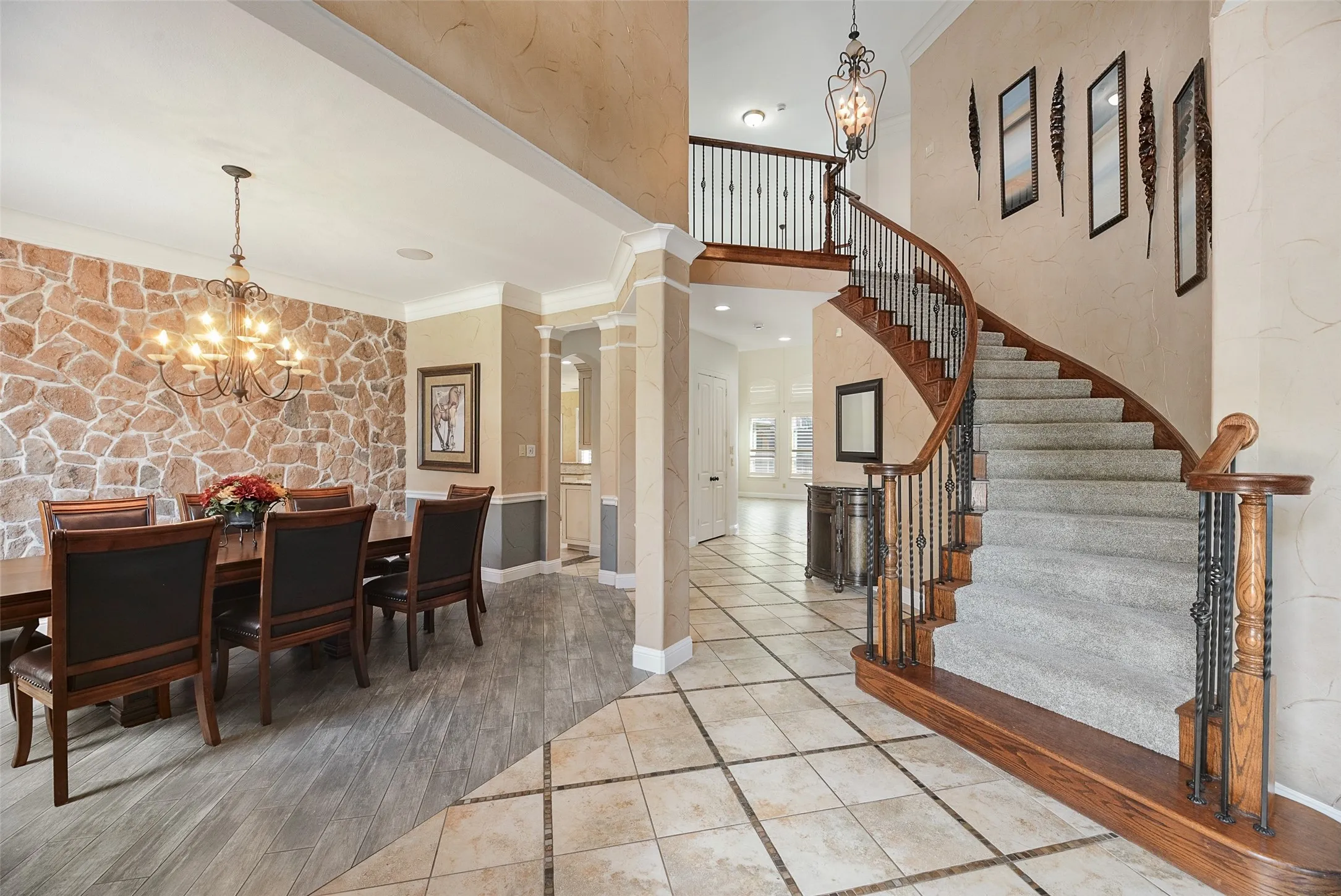 Grand entry with sweeping curved staircase, with wood handrails and wrought-iron balusters. Formal Dining with floor to ceiling accent wall.
