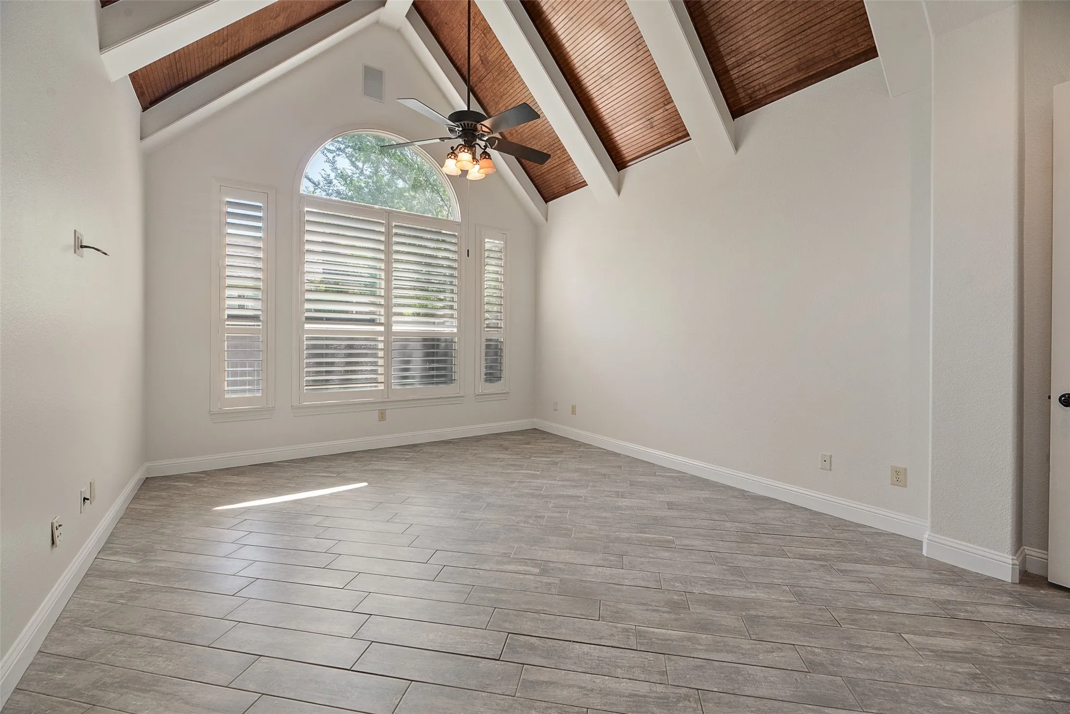 Master with vaulted ceiling featuring wood-plank insets and contrasting beams.