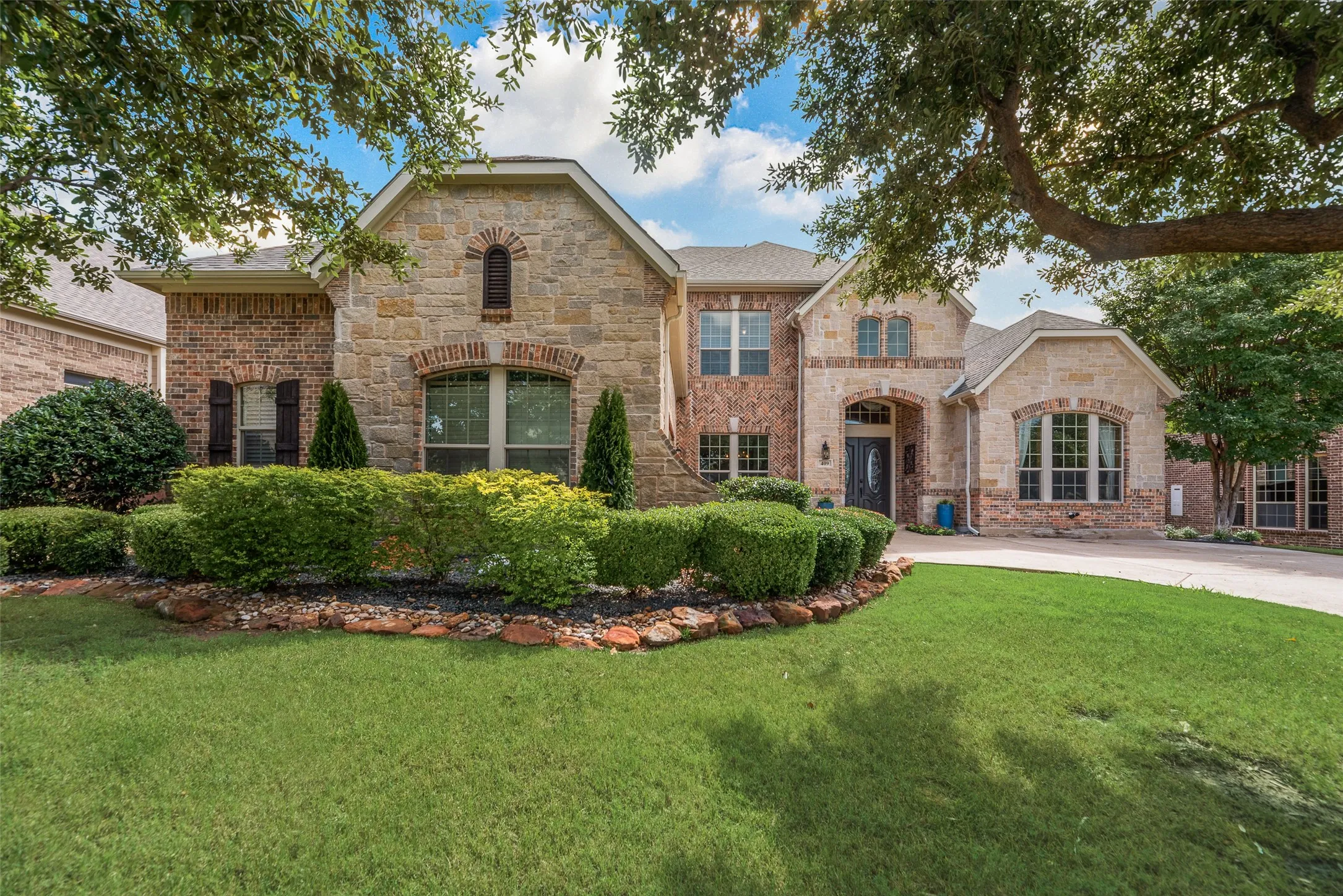 Mature shade trees, lush lawn, and meticulously maintained landscaping.