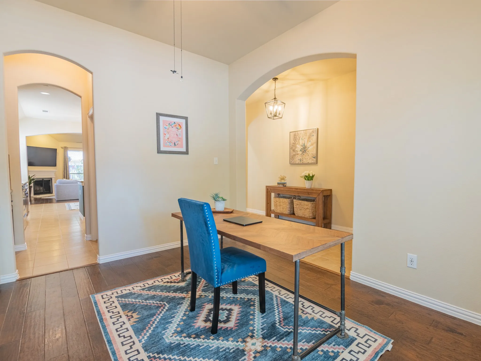 Hardwood-style flooring, arched doorways, light neutral wall tones, and recessed lighting