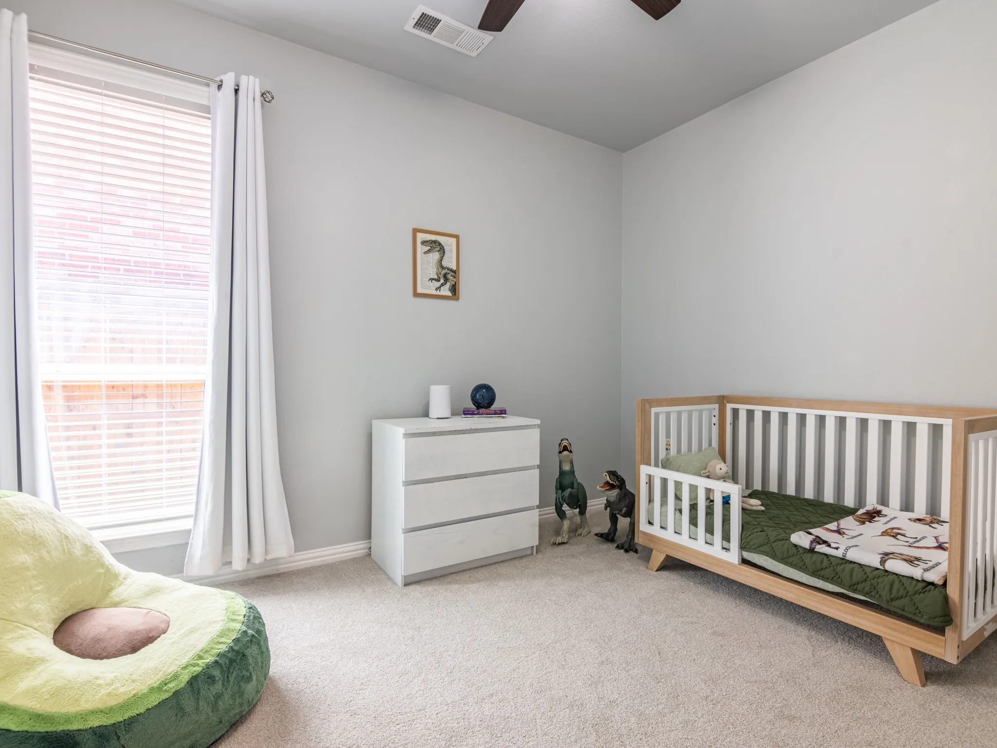 Light gray wall paint, textured carpeting, window with blinds, and ceiling fan