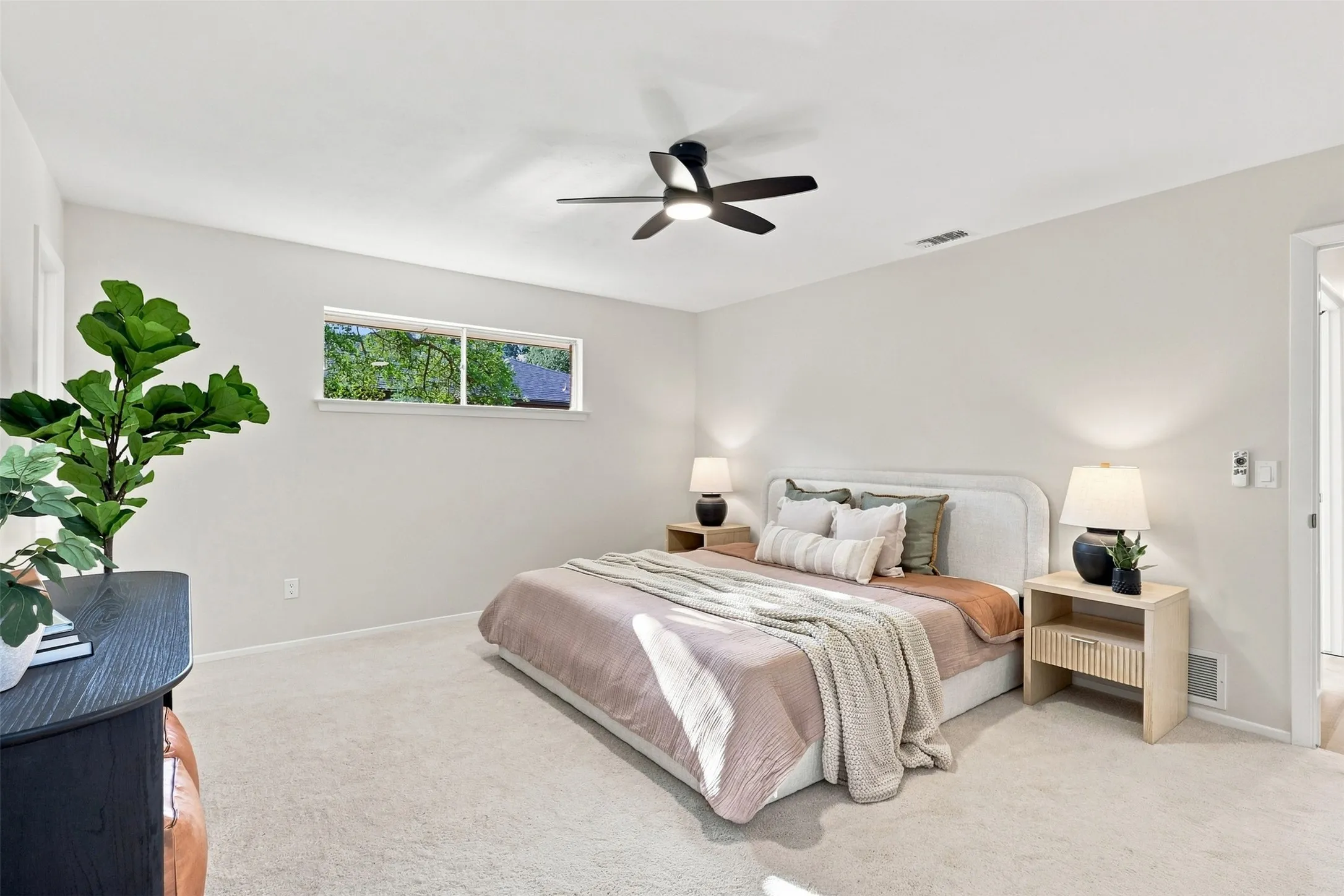 Recessed window with exterior greenery, neutral wall finishes, and carpeted flooring