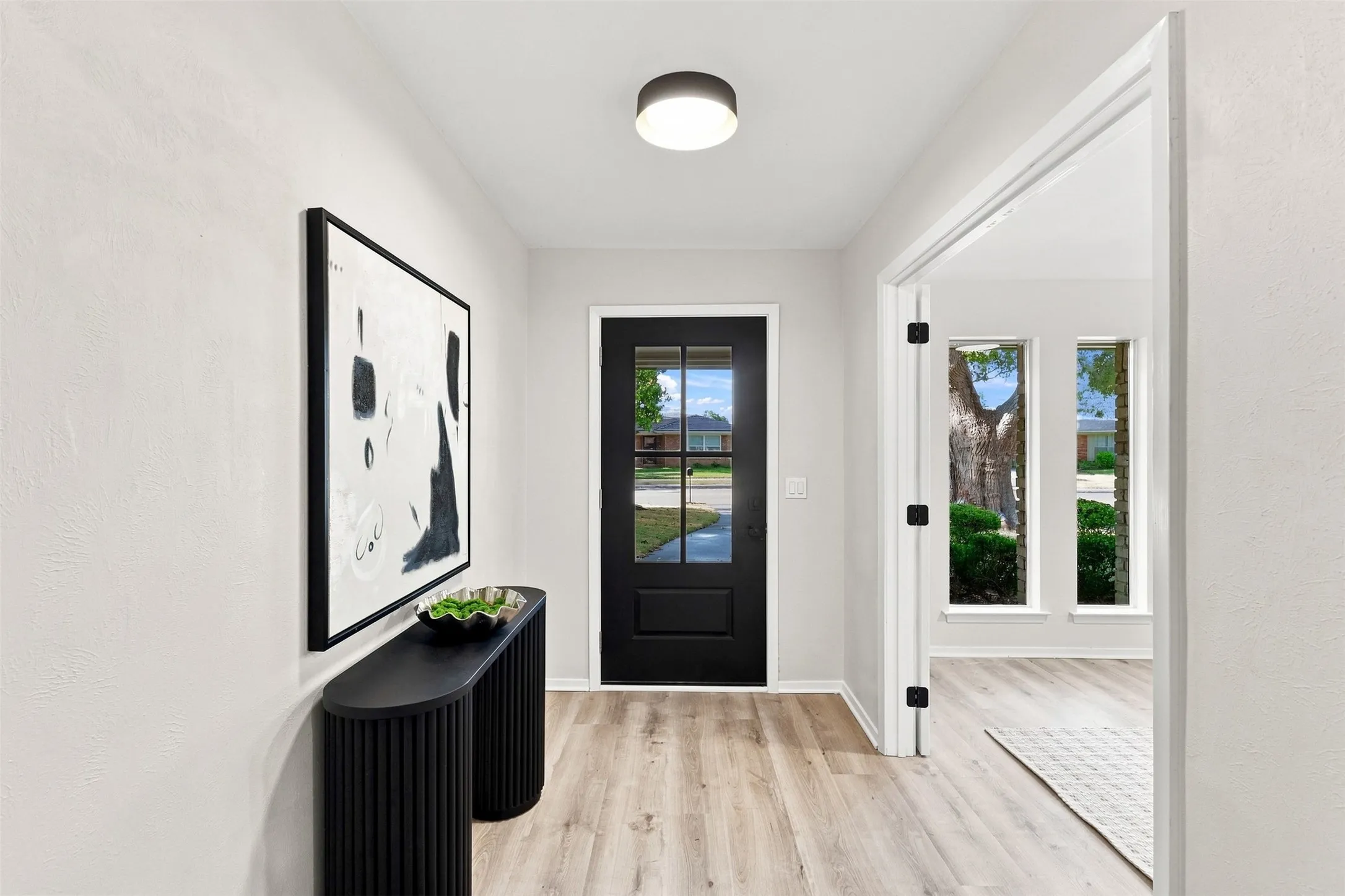 Light wood-finish flooring complements the neutral wall color