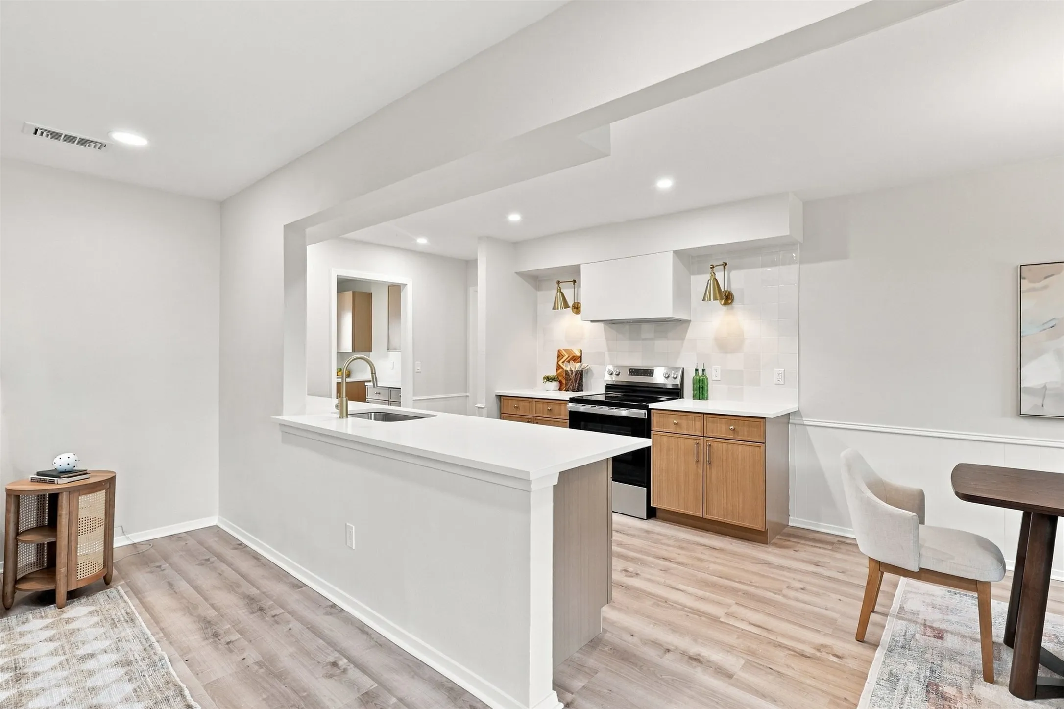 Open-concept kitchen with a white countertop island and gold-finish fixtures