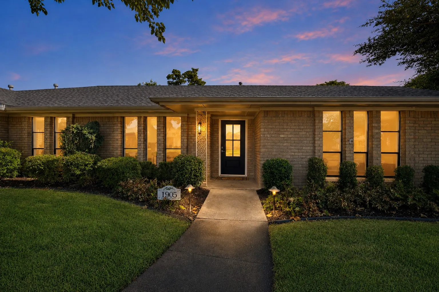 Brick exterior with a dark entry door and sidelight