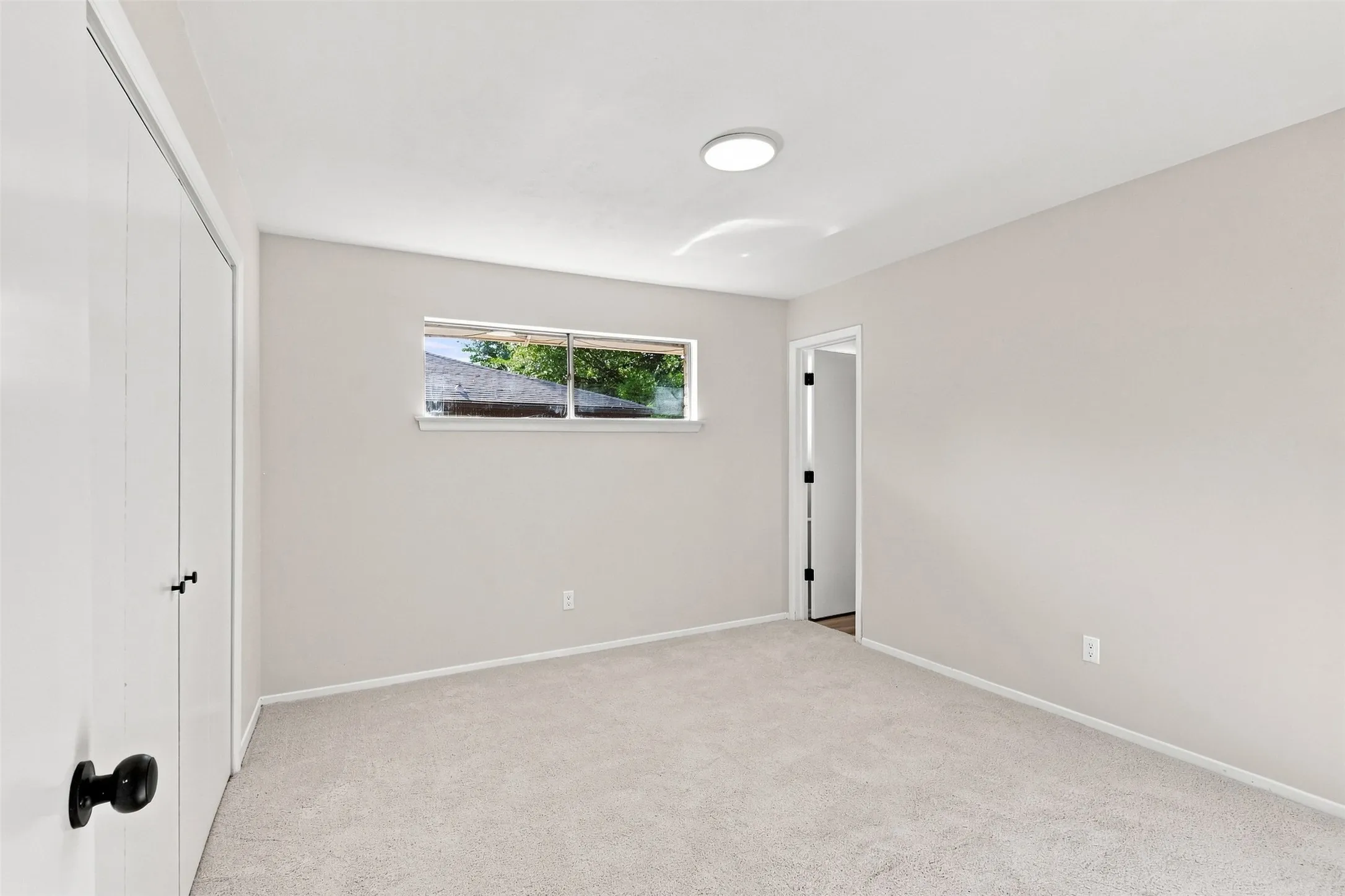 Neutral-toned walls complement the light-colored carpeting