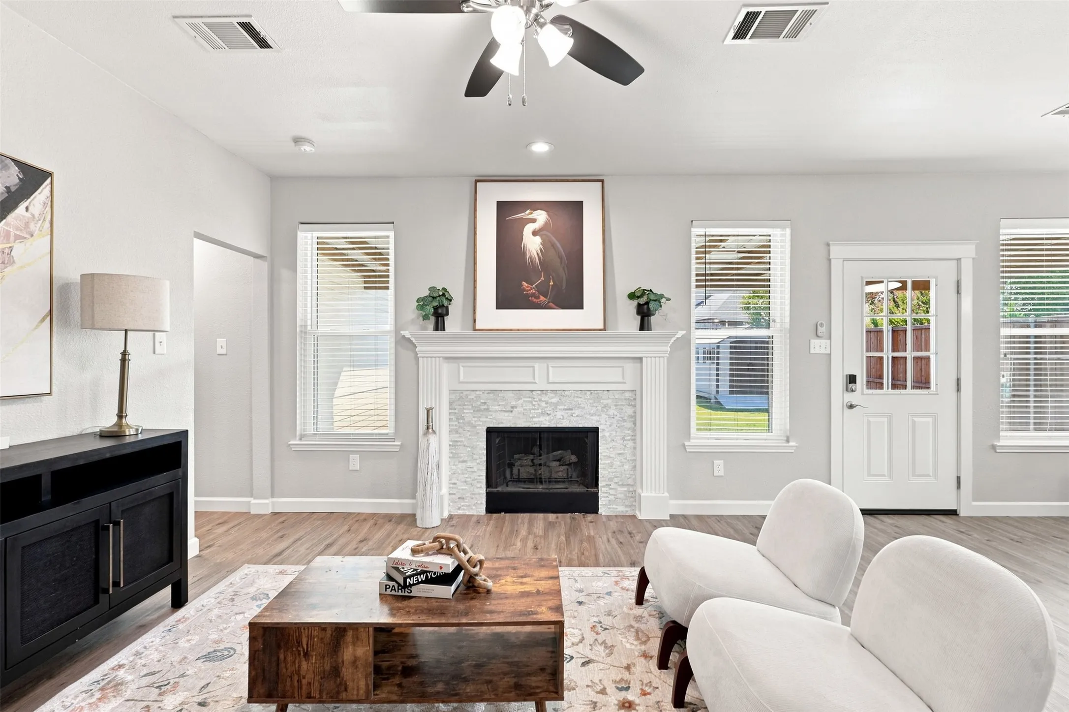 Alternate view of living room looking towards backyard and hallway leading to the primary bedroom.