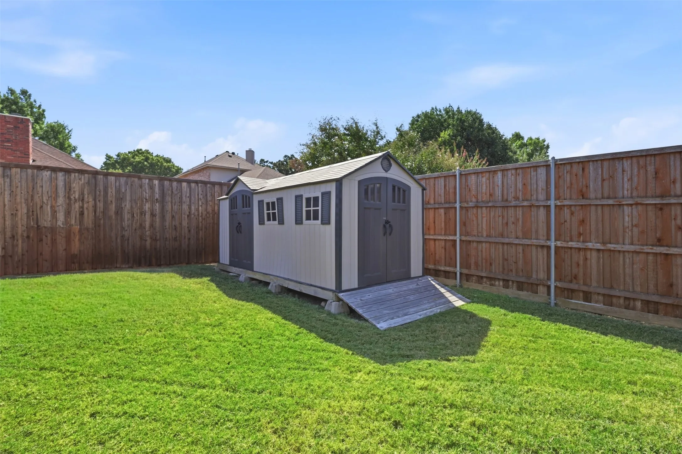 Storage shed in yard is perfect for storing tools and lawn equipment.