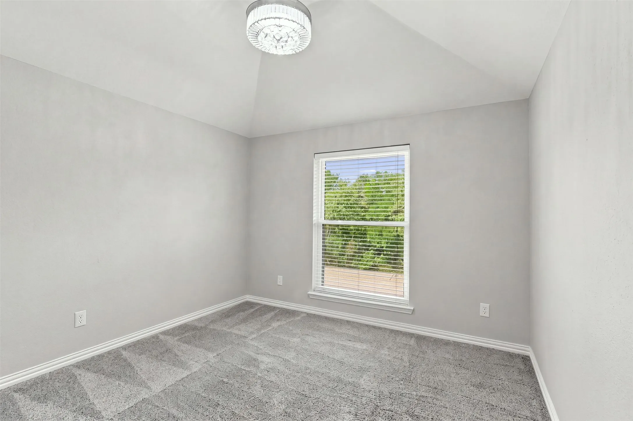 Fourth bedroom with carpet and tall ceilings.
