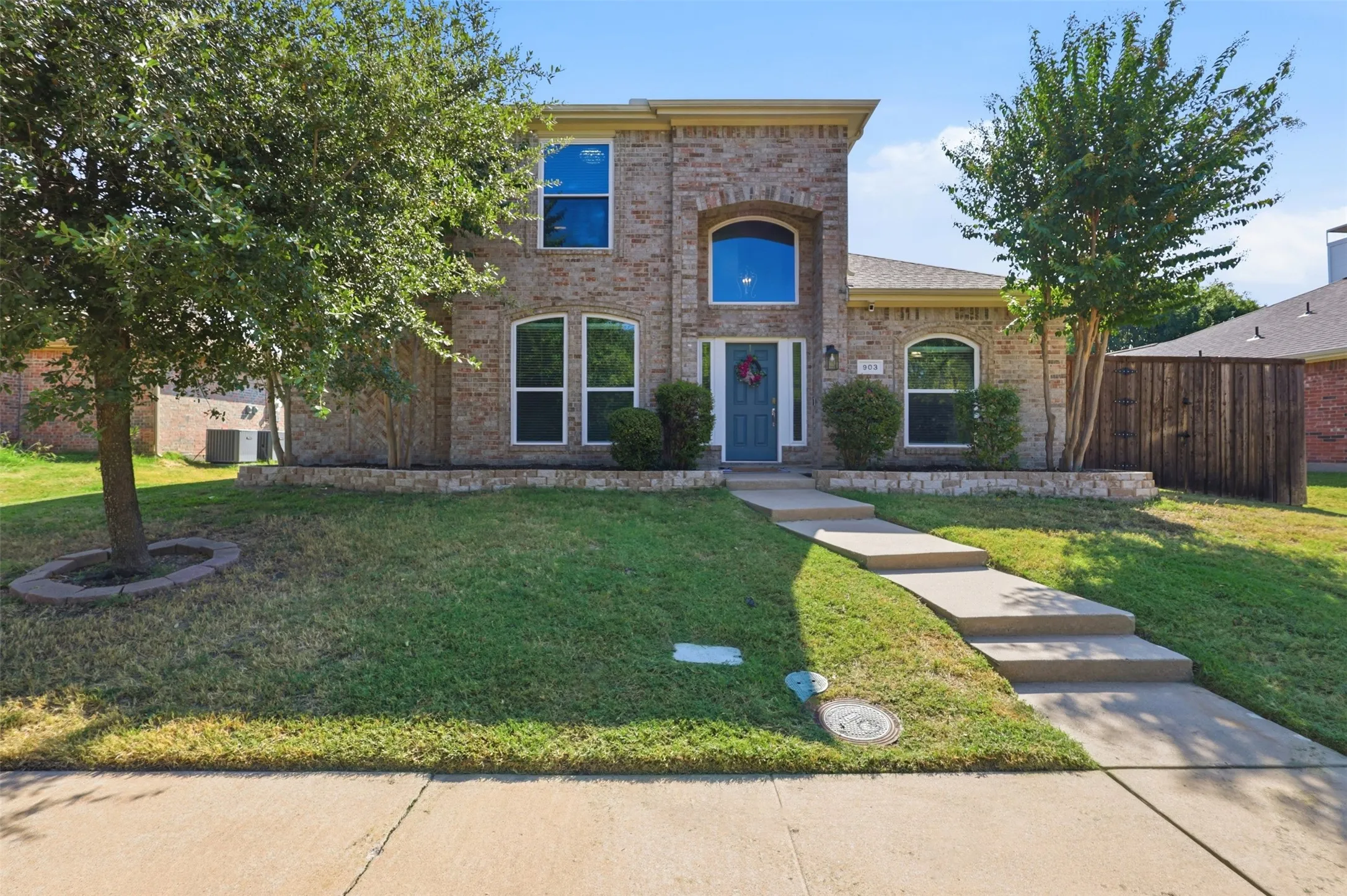 Beautiful brick home with mature trees and landscaping.