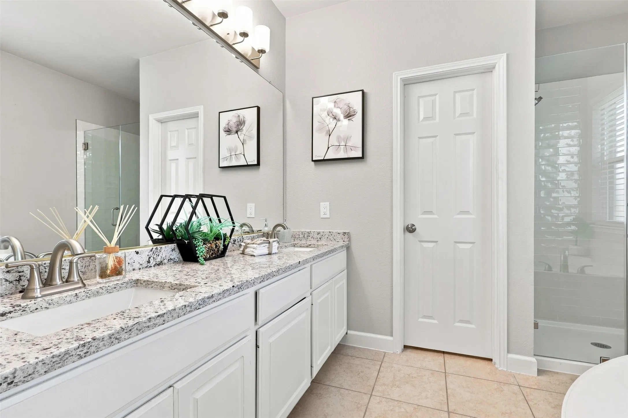 Primary bathroom featuring dual sinks, granite countertops, and separate shower/ bathtub.
