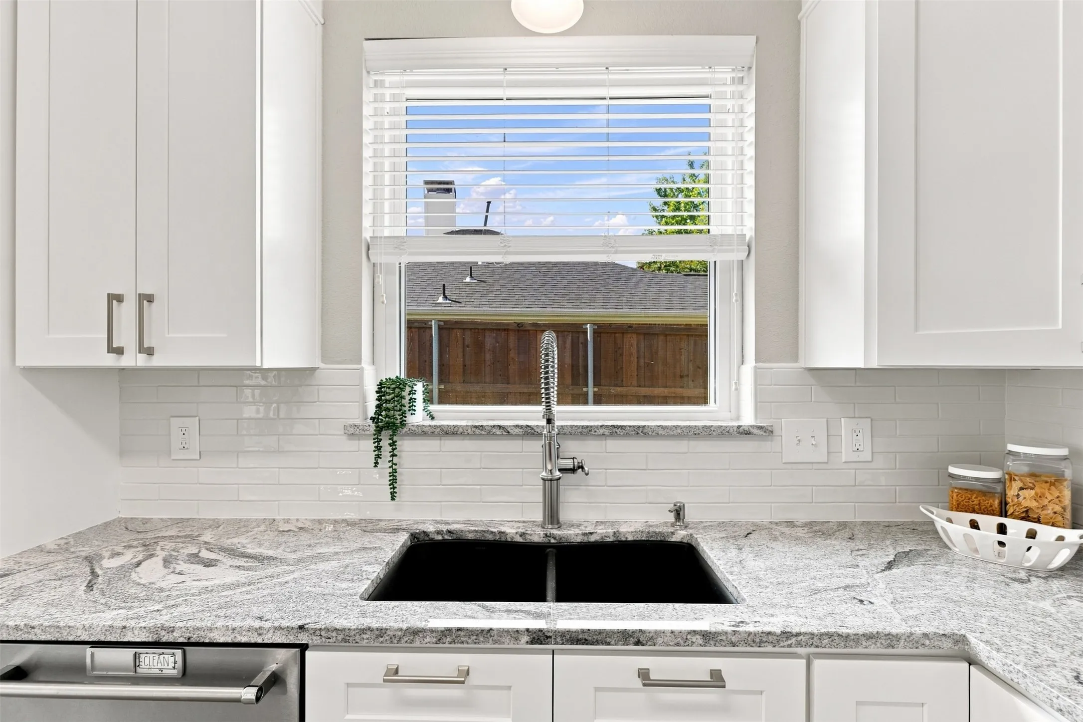 Charming kitchen window above sink overlooks the backyard.