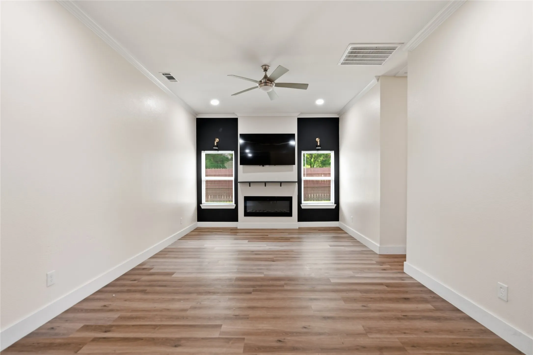 Spacious living area featuring wood-finish flooring, recessed lighting, and a ceiling fan