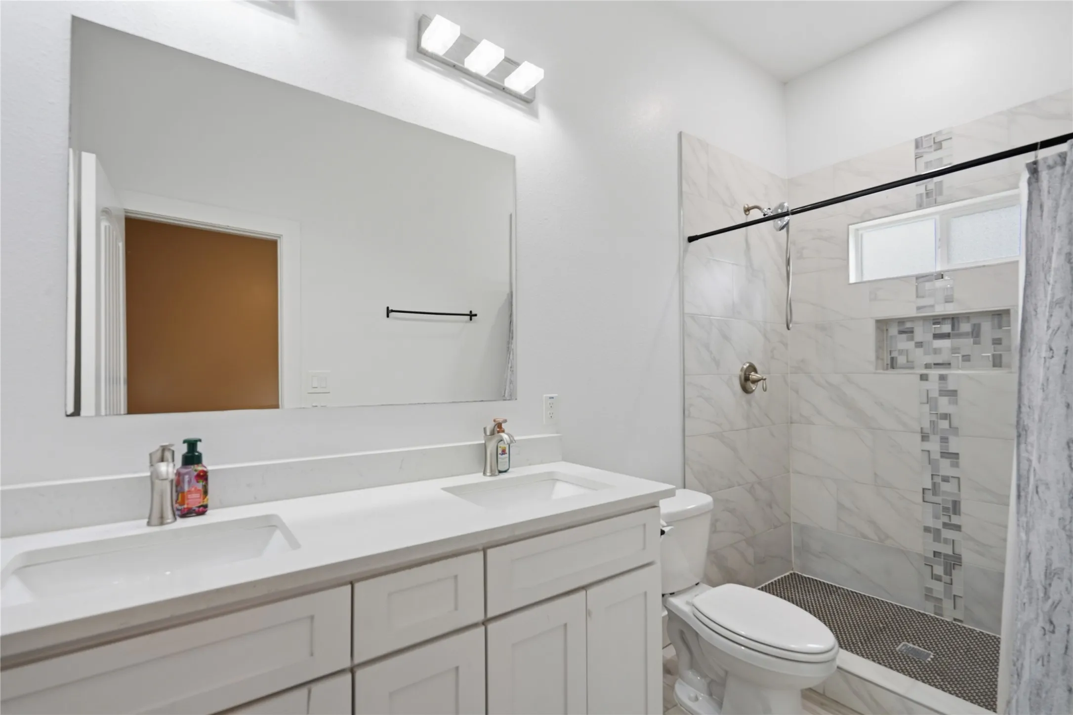 Contemporary bathroom featuring a double vanity and beautiful shower