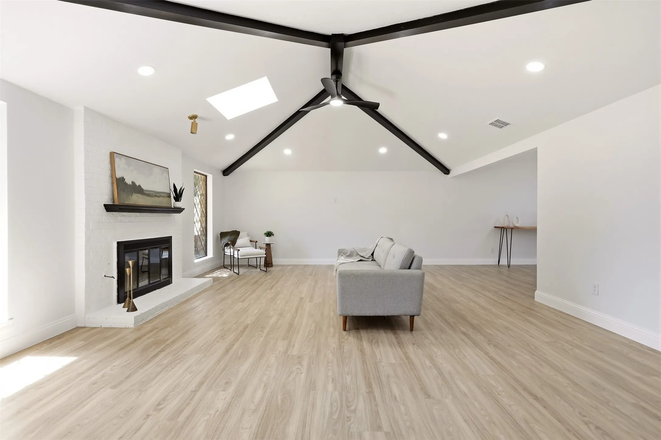 Vaulted ceilings with exposed beams, wood-finish flooring, recessed lighting, and a ceiling fan
