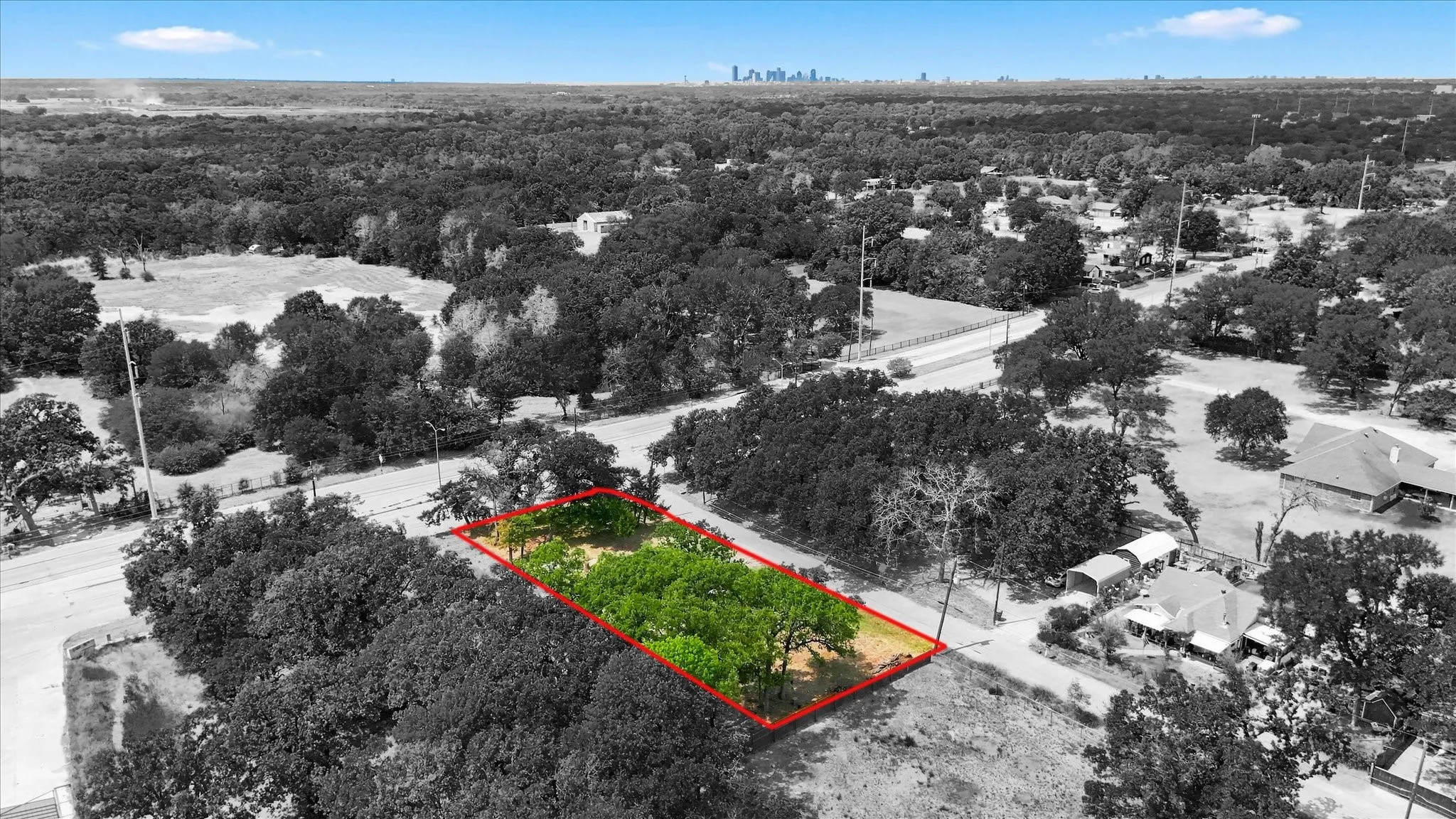 Lot outlined in red with downtown Dallas skyline on the horizon. Boundary lines approximate.
