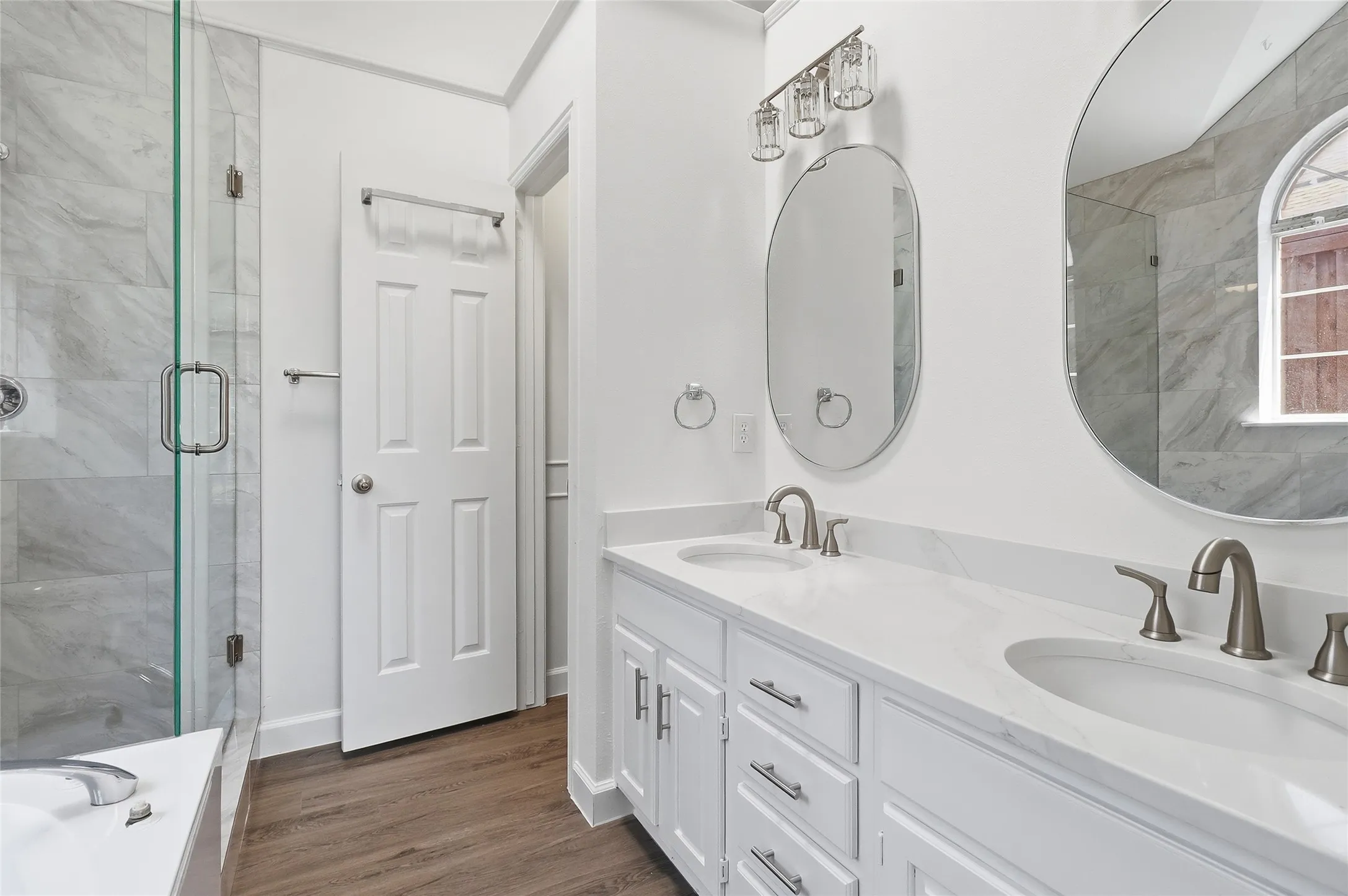 Frameless shower door, designer tile, quartz counter top, framed mirrors, under mount sinks