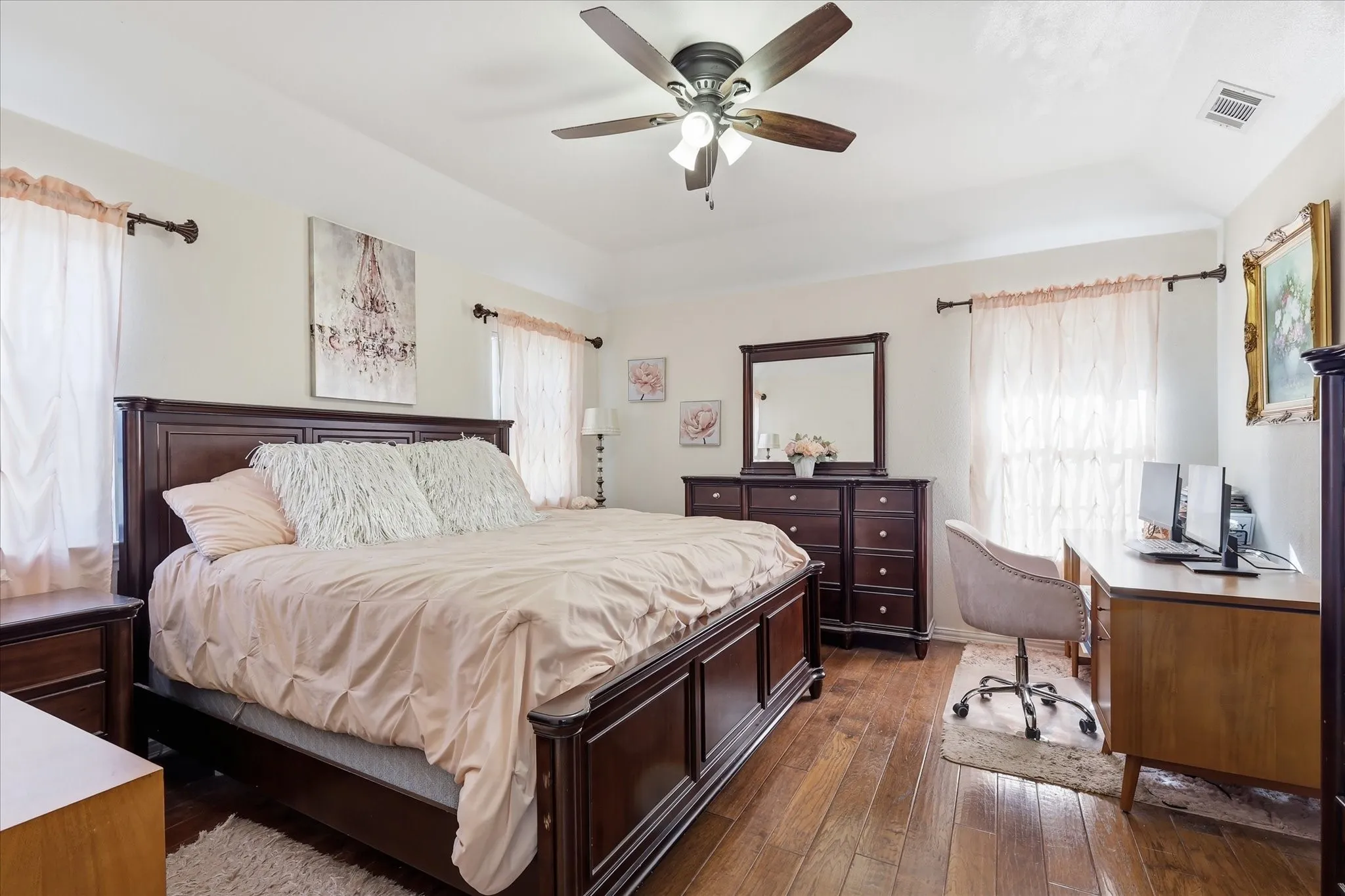 Tray ceiling, recessed lighting, wood-finish flooring, ceiling fan with integrated lighting, multiple windows