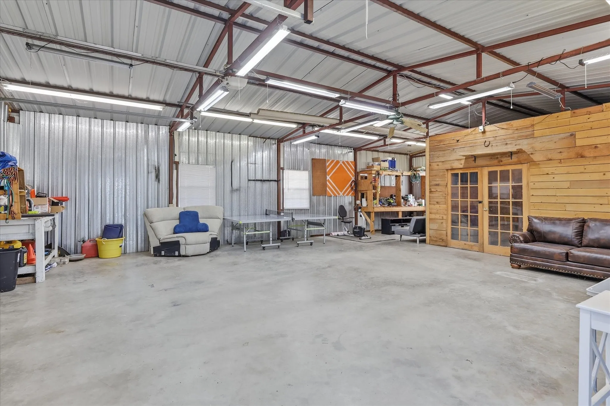 Expansive open space featuring a concrete floor, corrugated metal walls, and a metal truss ceiling