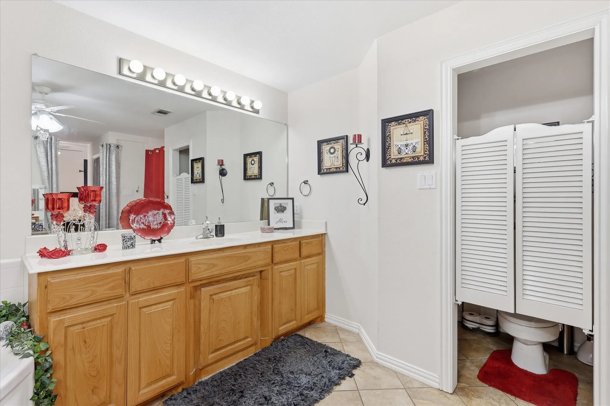 Expansive vanity with wood-finish cabinetry, a white countertop, and an integrated sink