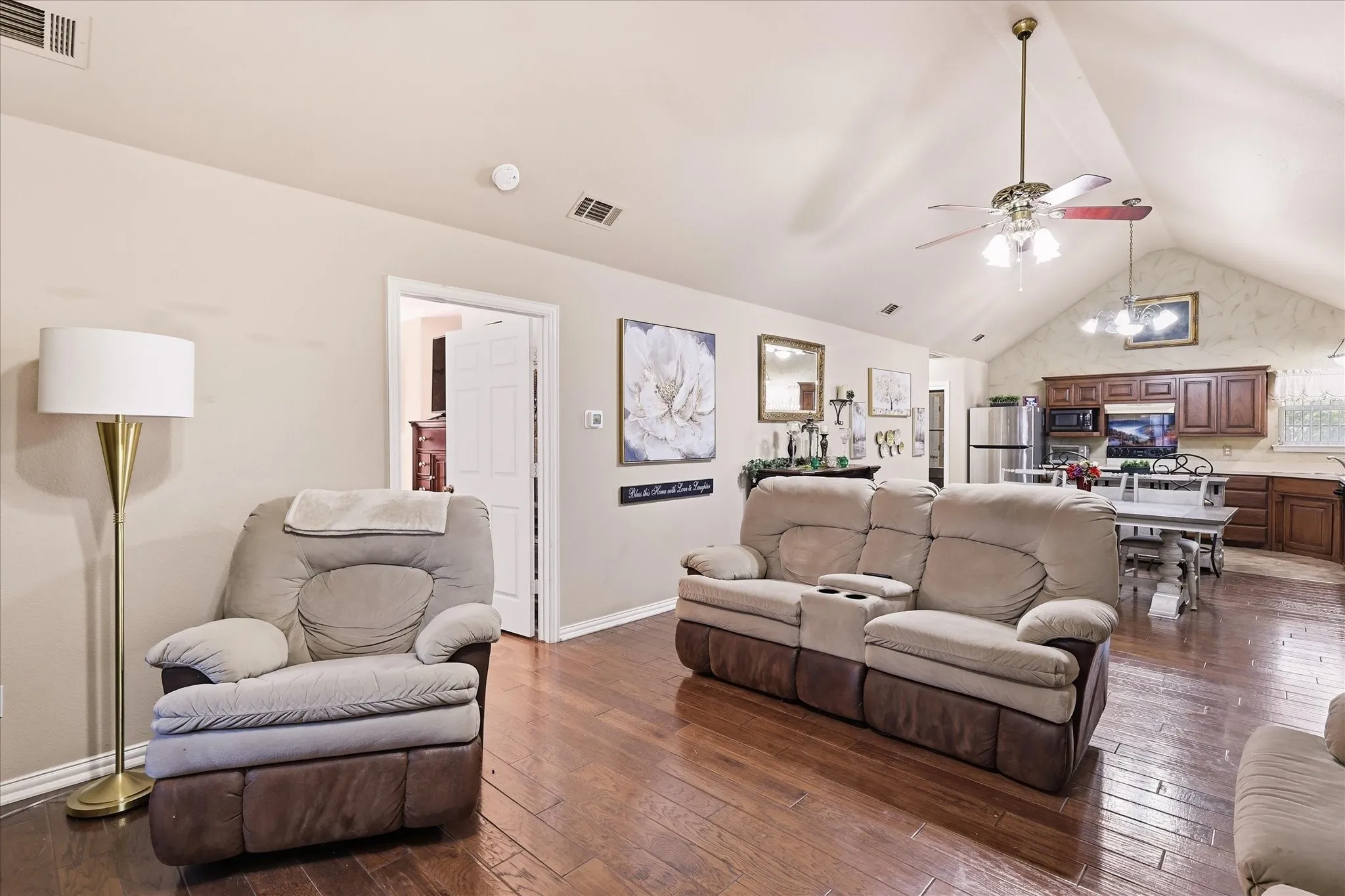 Vaulted ceiling with an attached ceiling fan, wood-finish flooring, and recessed lighting