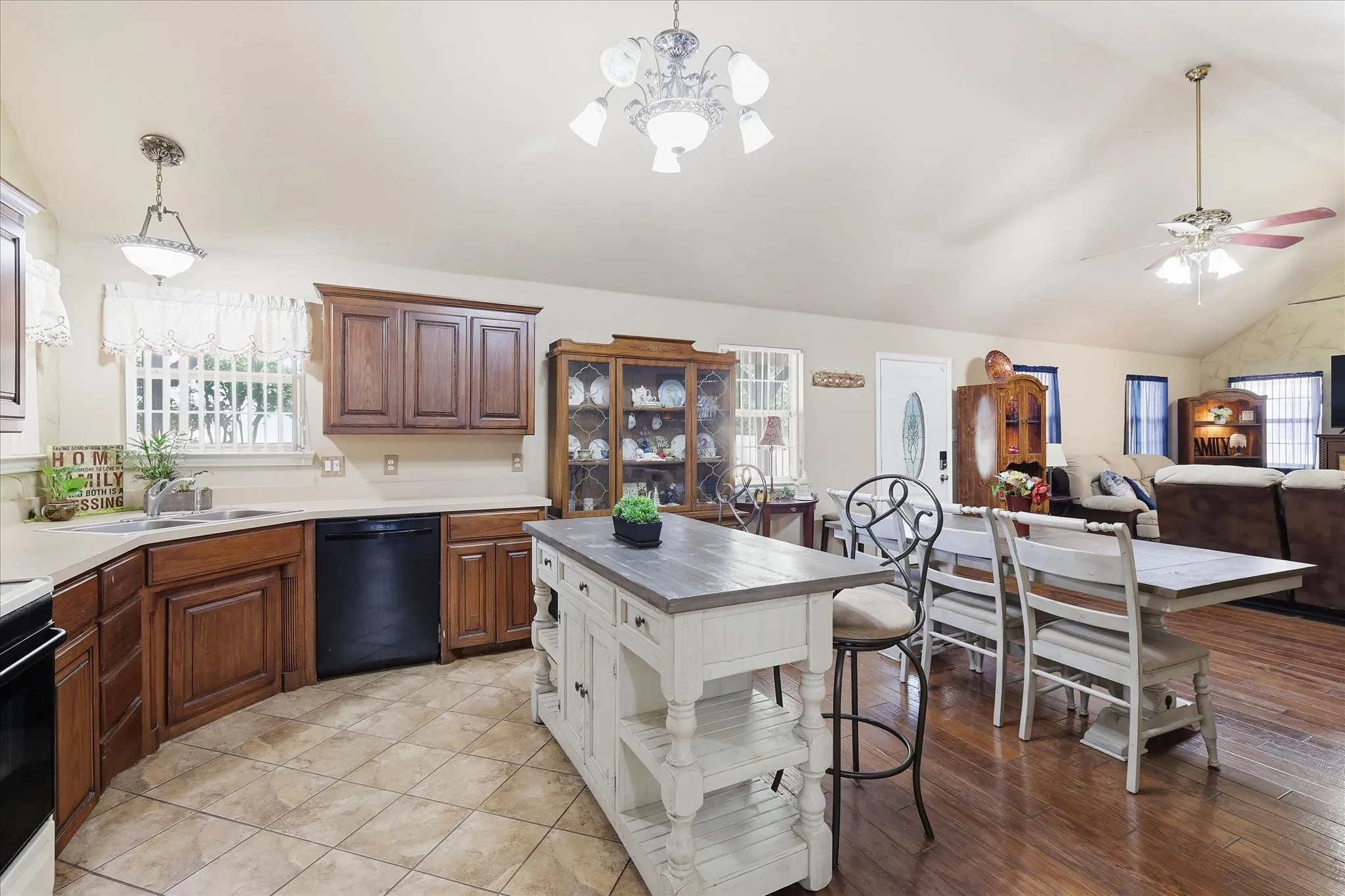 Vaulted ceiling with ceiling fan, wood-finish flooring, kitchen island, wood cabinetry, and recessed lighting