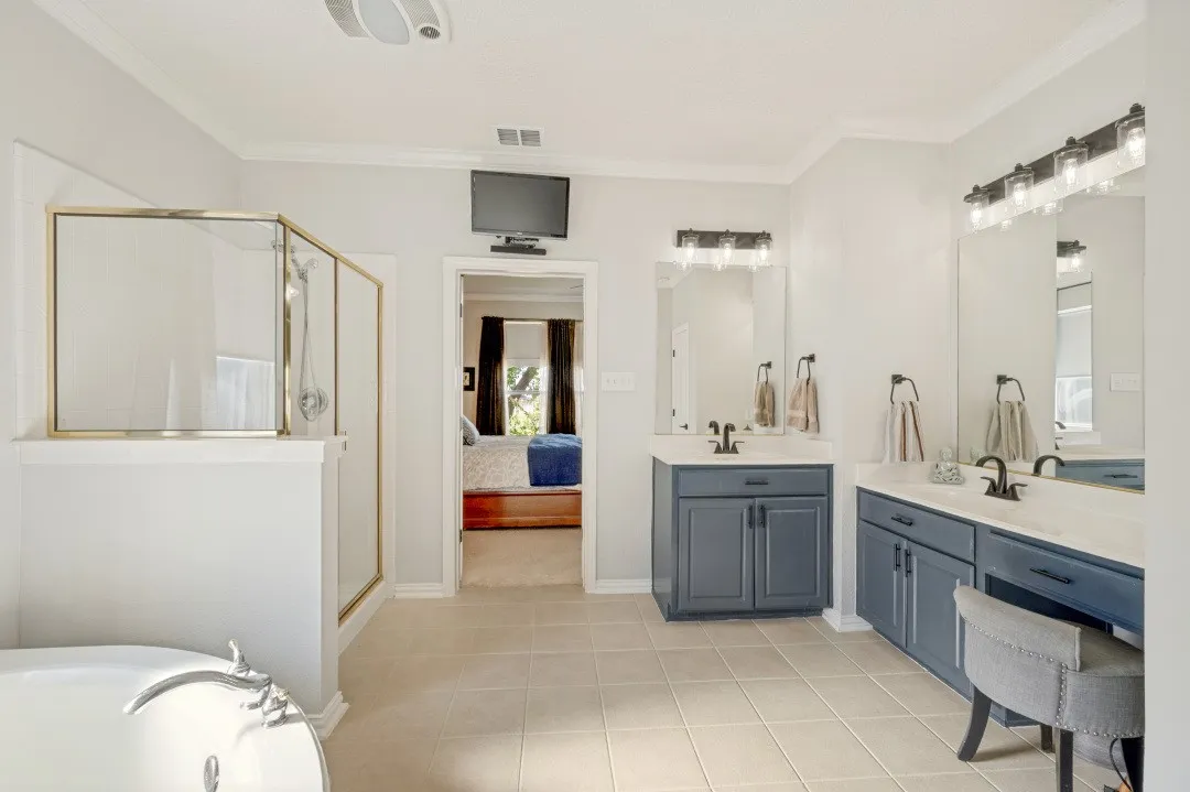 Dual vanity with integrated sinks, framed mirrors, and contemporary lighting fixtures