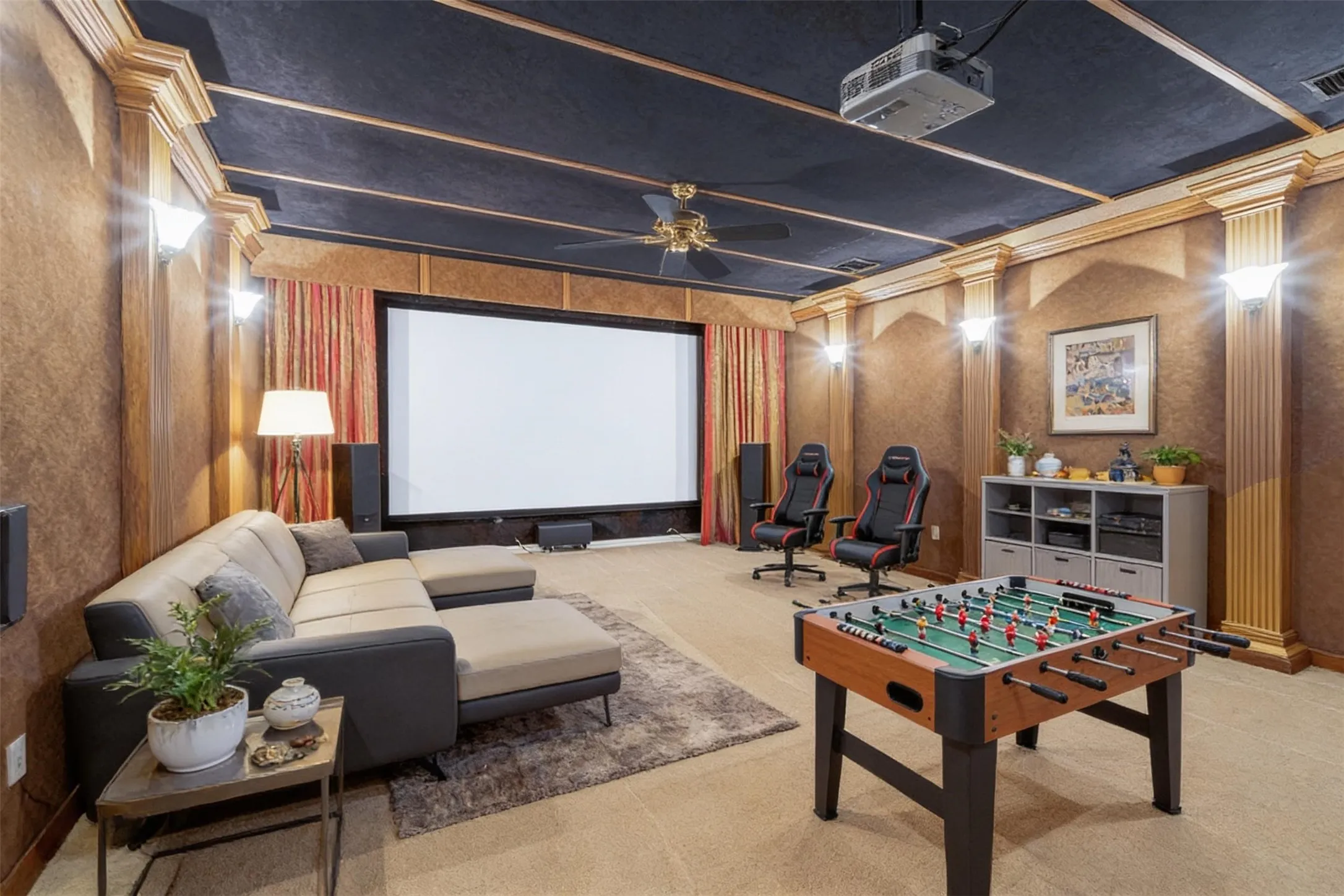 Dedicated entertainment room featuring a large projection screen, integrated ceiling projector, and ceiling fan