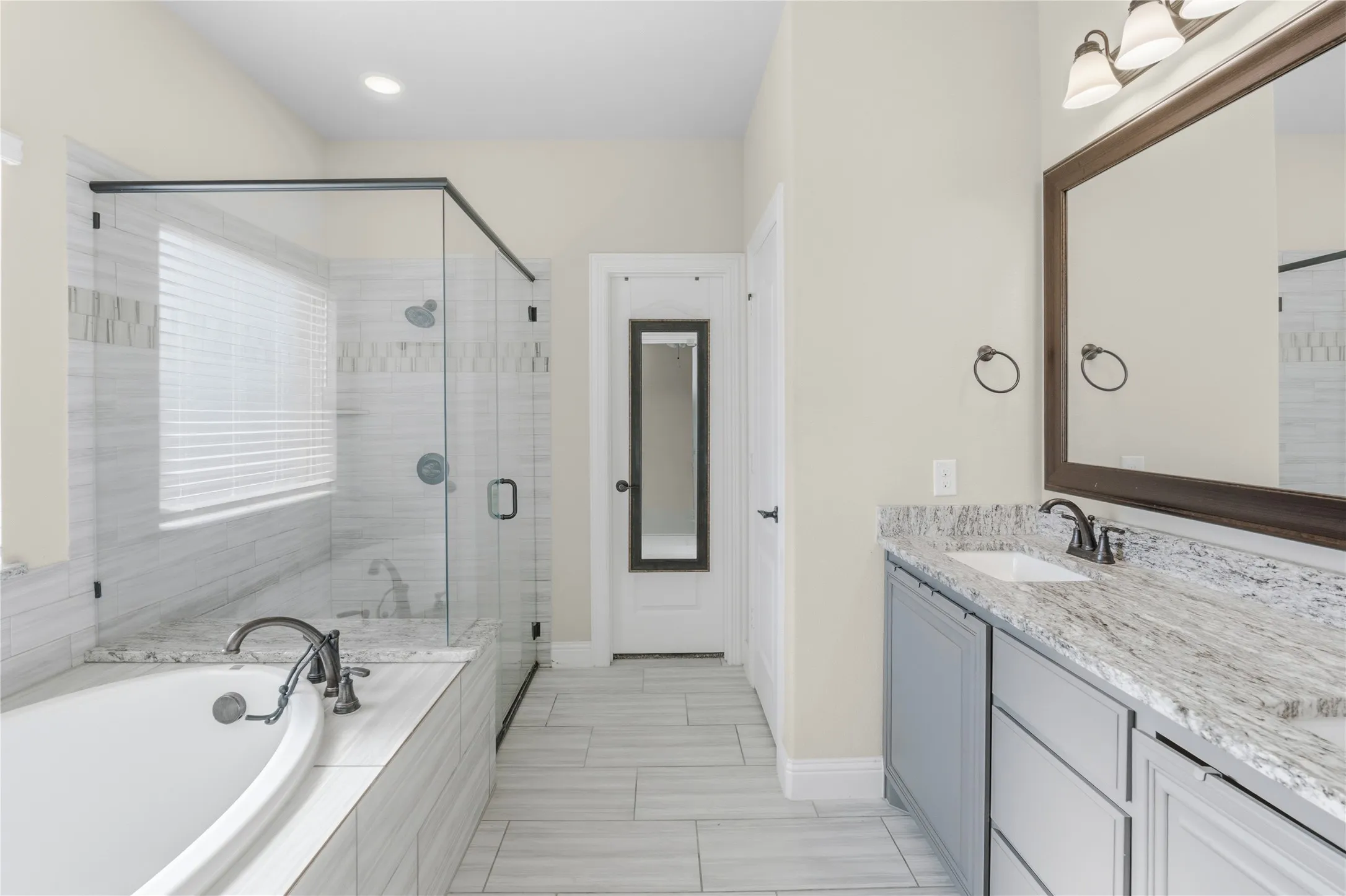 Full bath featuring double vanity, a shower stall, and a bath
