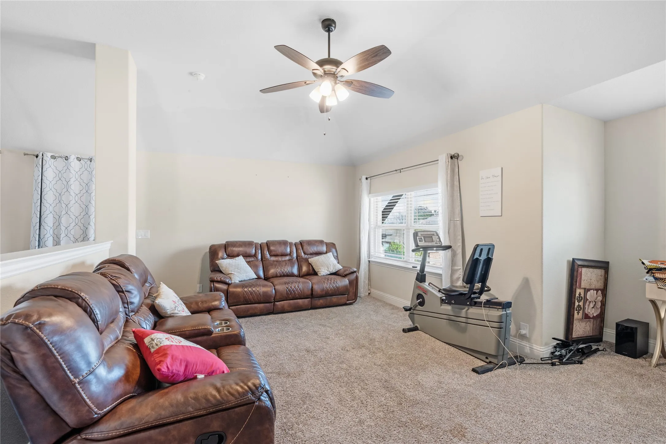 Carpeted living area with lofted ceiling and ceiling fan