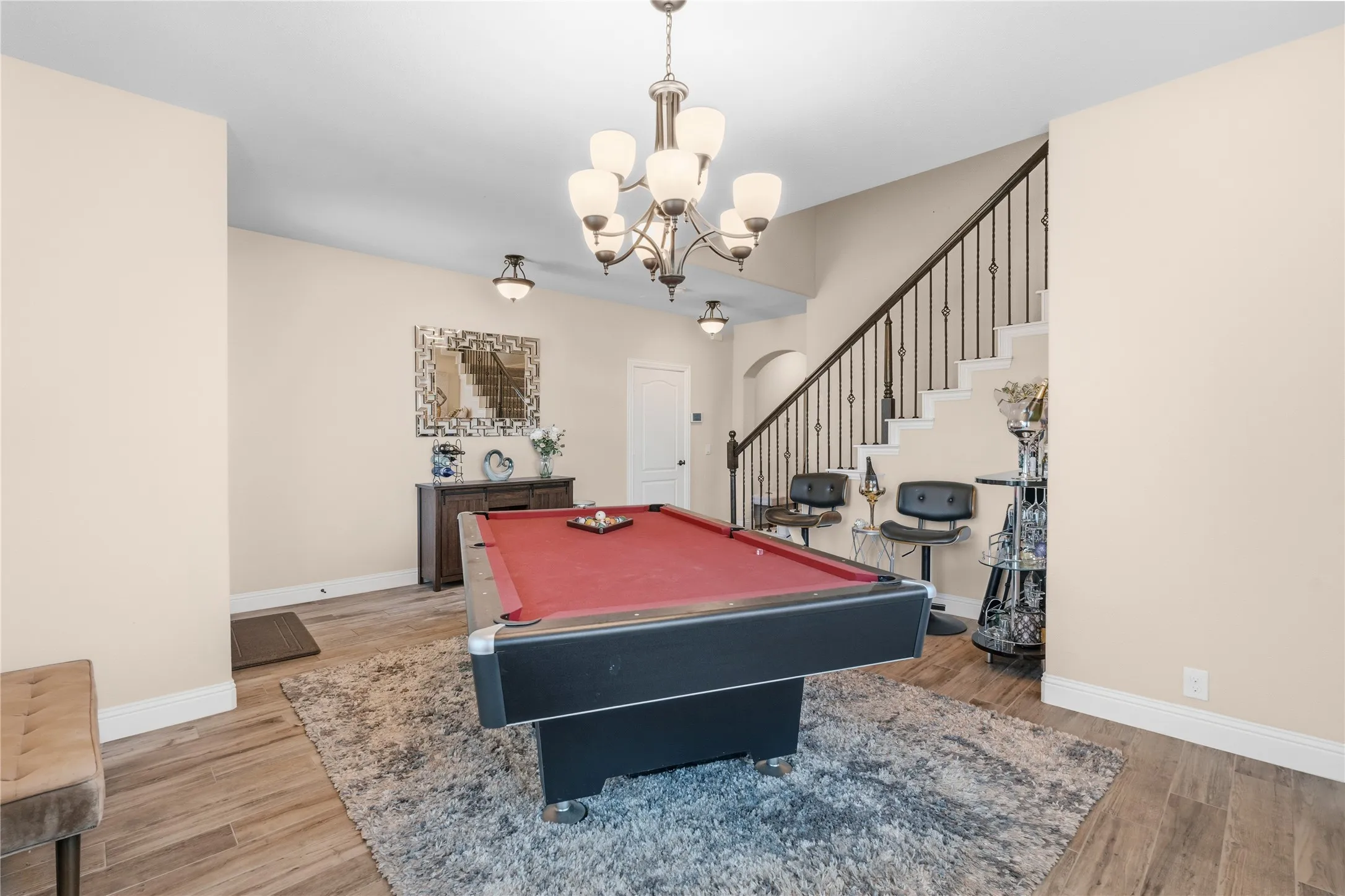 Rec room featuring pool table, light wood finished floors, and hanging lights