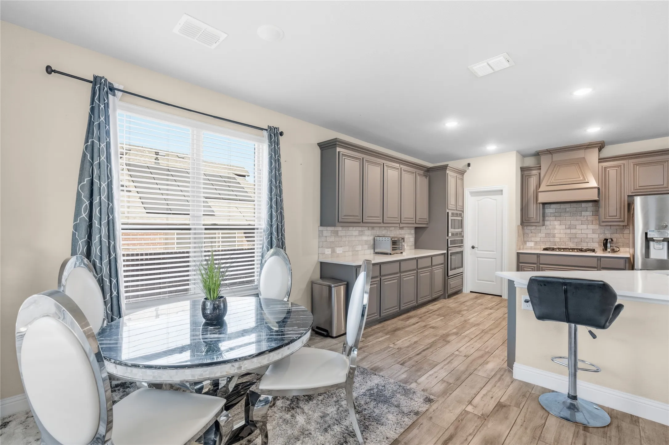 Dining room with light wood-style floors and recessed lighting
