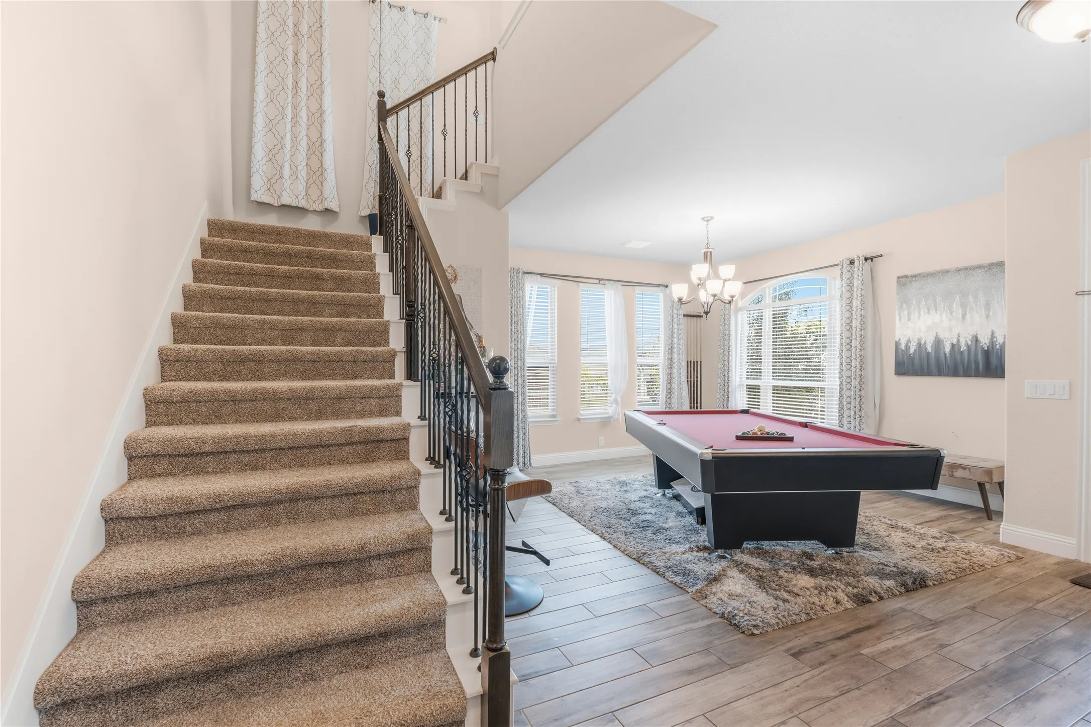 Recreation room with light wood-style flooring, billiards table, and a chandelier