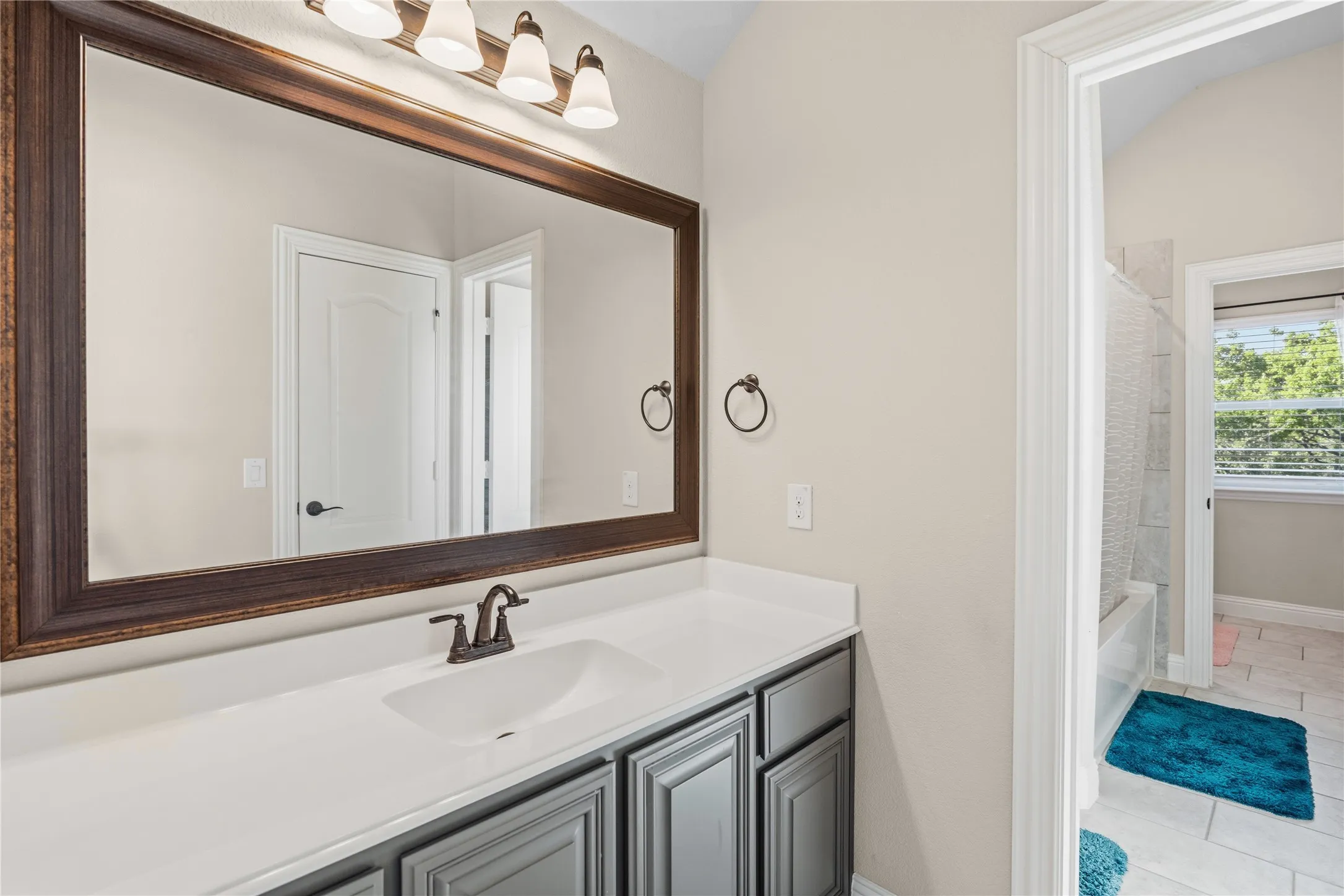Bathroom featuring vanity, washtub / shower combination, and light tile patterned flooring