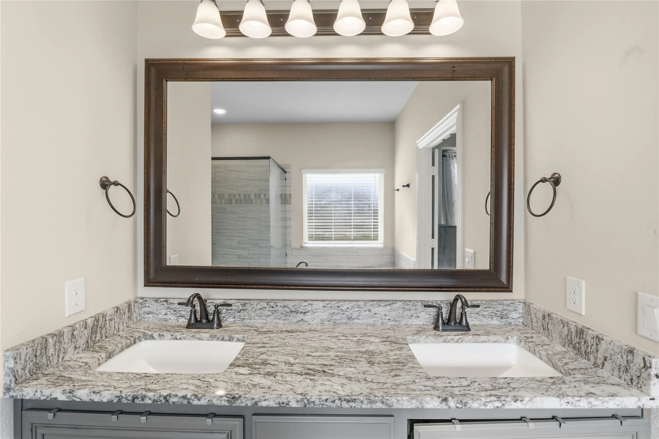Bathroom featuring double vanity and a shower stall