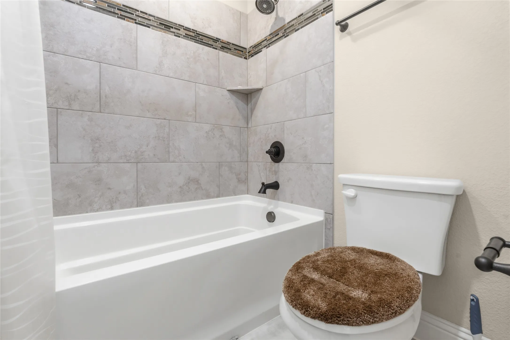 Bathroom featuring toilet and shower / tub combo with curtain