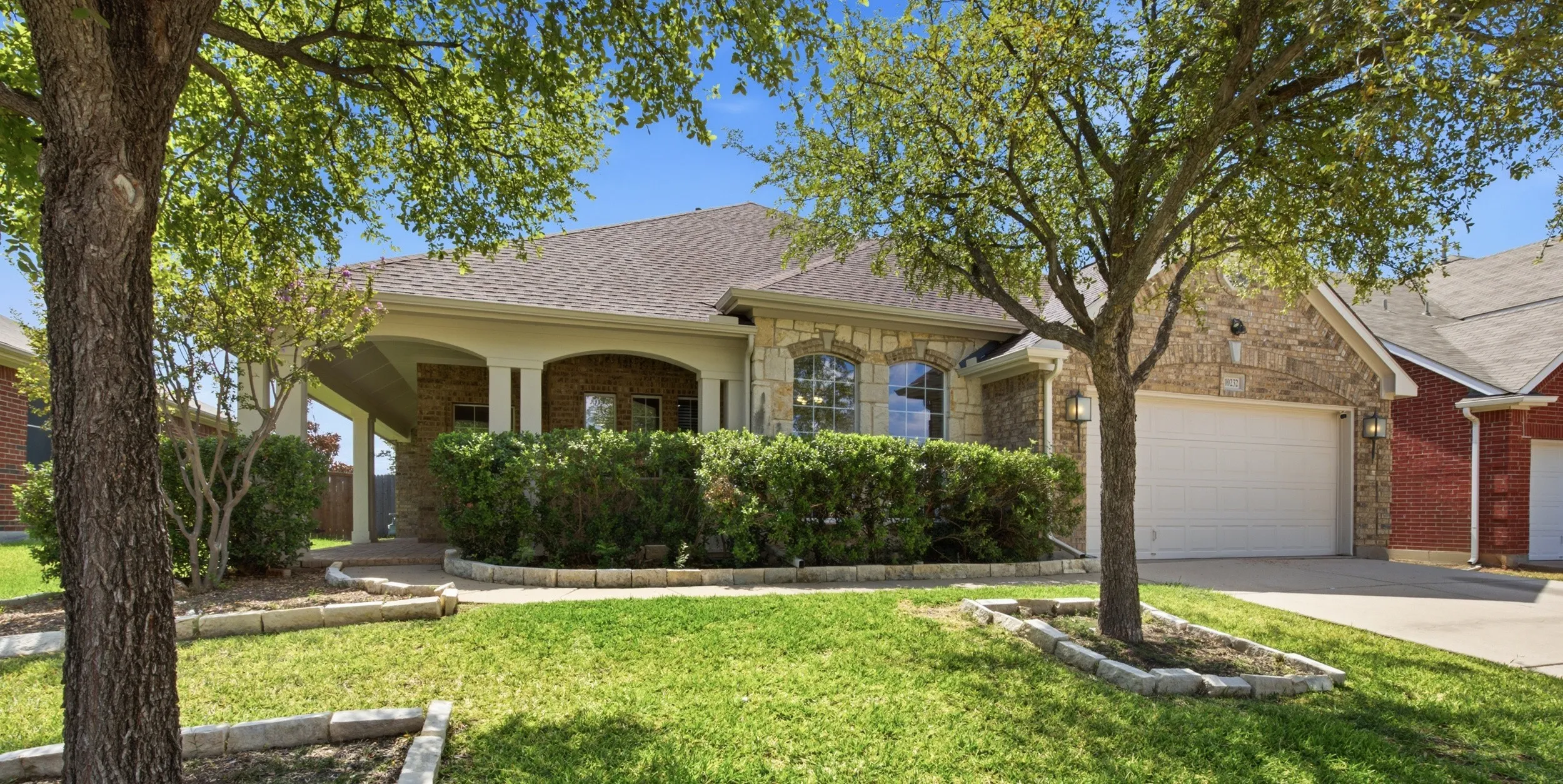 Wonderful trees in front of home and wrap-around porch to enjoy as well at 10232 Ash Creek Lane listed by Seth Fowler of Williams Trew Real Estate
